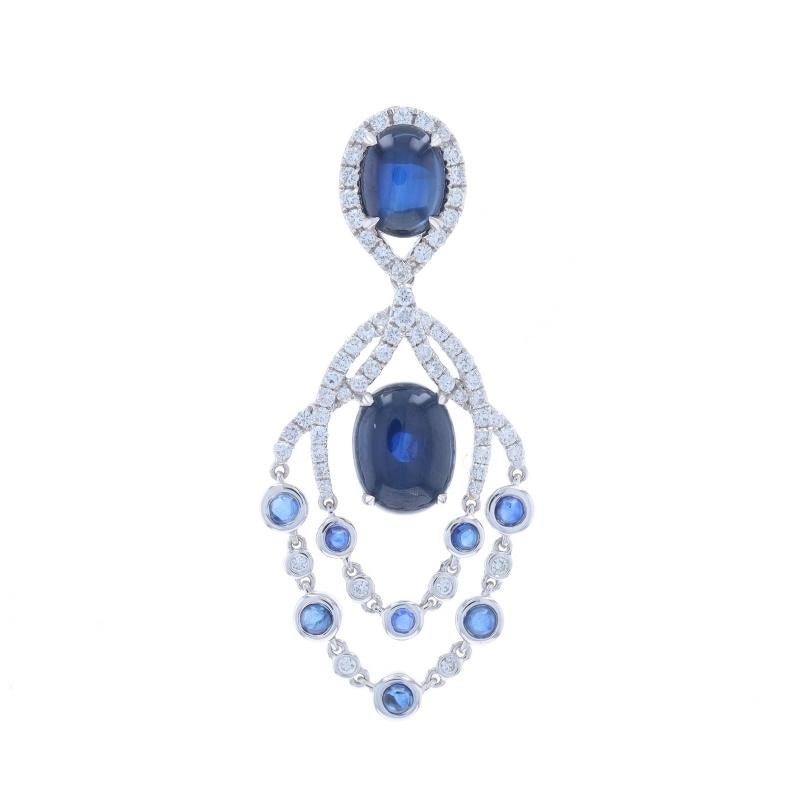Metal Content: 18k White Gold

Stone Information

Natural Sapphires
Treatment: Heating
Carat(s): 4.66ctw (carat stamp)
Cut: Oval Cabochon
Color: Blue

Natural Sapphires
Treatment: Heating
Carat(s): .63ctw (carat stamp)
Cut: Round Cabochon
Color: