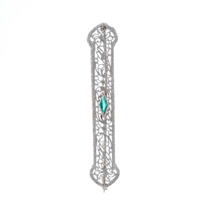 Era: Art Deco
Date: 1920s - 1930s

Metal Content: 10k White Gold

Stone Information

Simulated Emerald
Cut: Marquise
Color: Green

Style: Bar Brooch
Fastening Type: Hinged Pin with Locking C-Clasp
Features: Milgrain Filigree

Measurements

Tall: