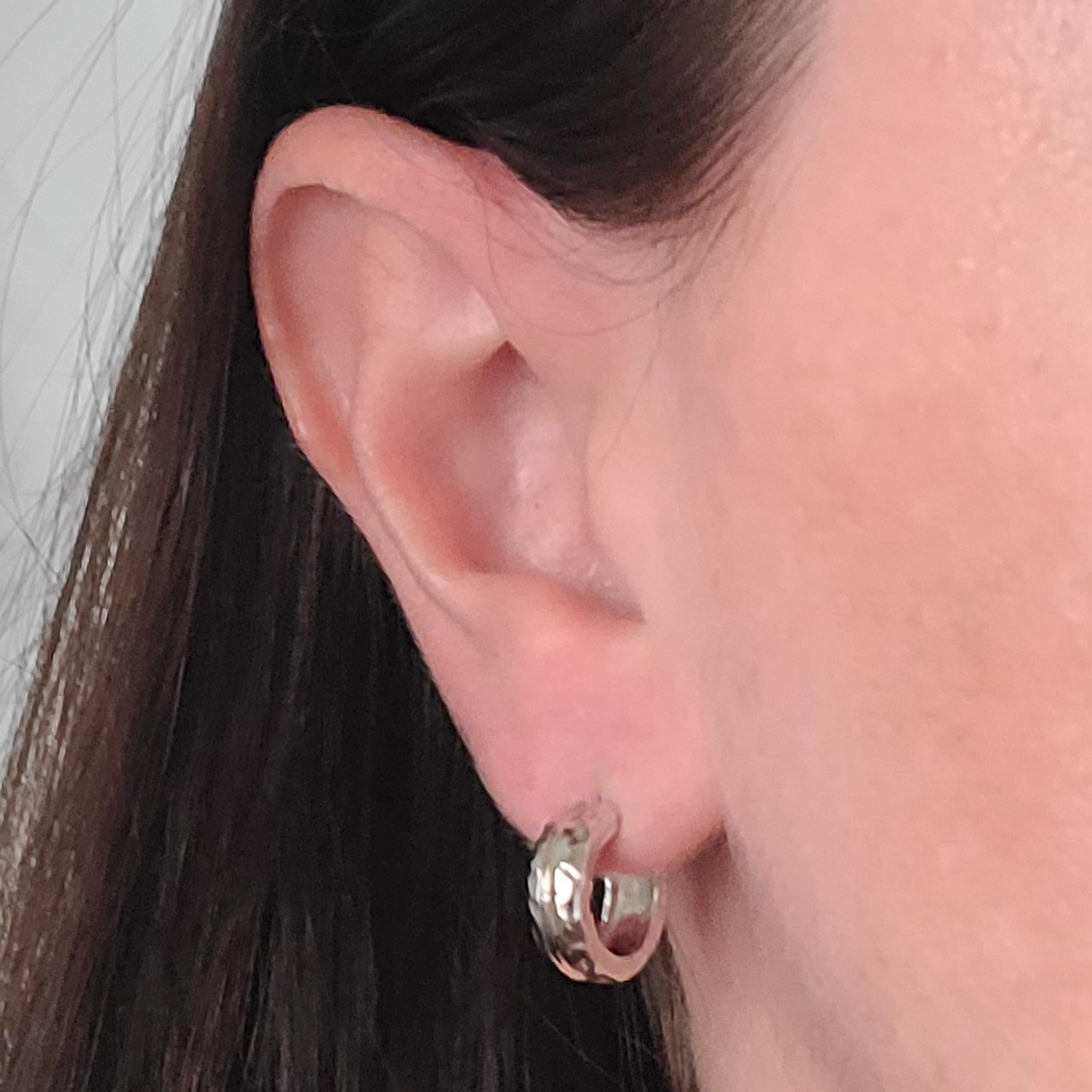 18 Karat White Gold 5mm Wide Huggie Hoop Earrings Measuring 13.5mm In Diameter. Hammered Edge with High Polish Center. Pierced Post With Friction Back. Finished Weight Is 5.3 Grams.