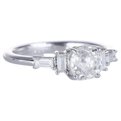 Bague solitaire en or blanc avec diamant central taillé en coussin et diamants latéraux baguettes