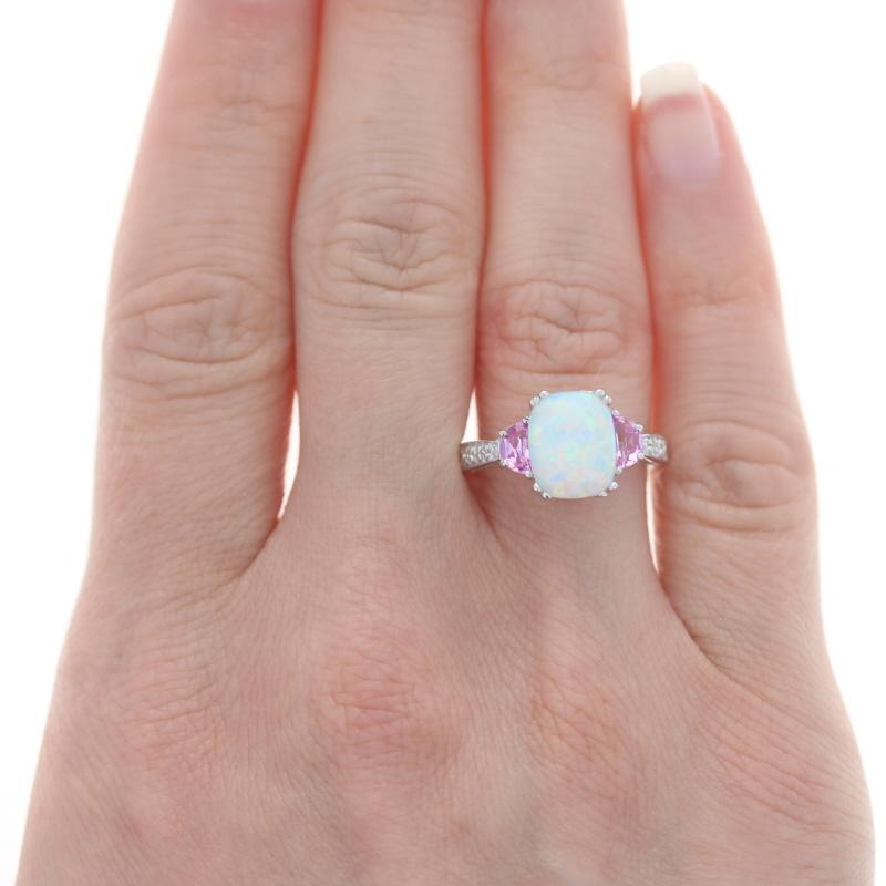 Size: 7 1/4
Sizing Fee: Up 2 sizes for $35 or Down 2 sizes for $30

Metal Content: 14k White Gold

Stone Information
Synthetic Opal
Carat(s): 1.30ct
Cut: Cushion Cabochon

Synthetic Sapphires
Carat(s): .65ctw
Cut: Half Moon
Color: Pink

Natural