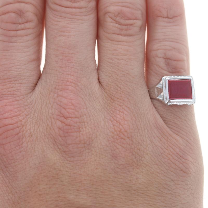 Size: 7 1/2
Sizing Fee: Up 1 size for $35 or Down 1 size for $30

Era: Art Deco
Date: 1920s - 1930s

Metal Content: 14k White Gold

Stone Information
Synthetic Ruby
Cut: Rectangular Step
Color: Red

Style: Solitaire
Features: East-West Set Stone