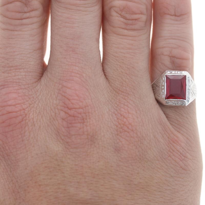Size: 8
Sizing Fee: Down 1 size for $40 or up 2 sizes for $50

Era: Art Deco
Date: 1920s - 30s

Metal Content: 14k White Gold

Stone Information

Synthetic Ruby
Cut: Rectangle 
Color: Red

Style: Solitaire 
Features: Etched & milgrain