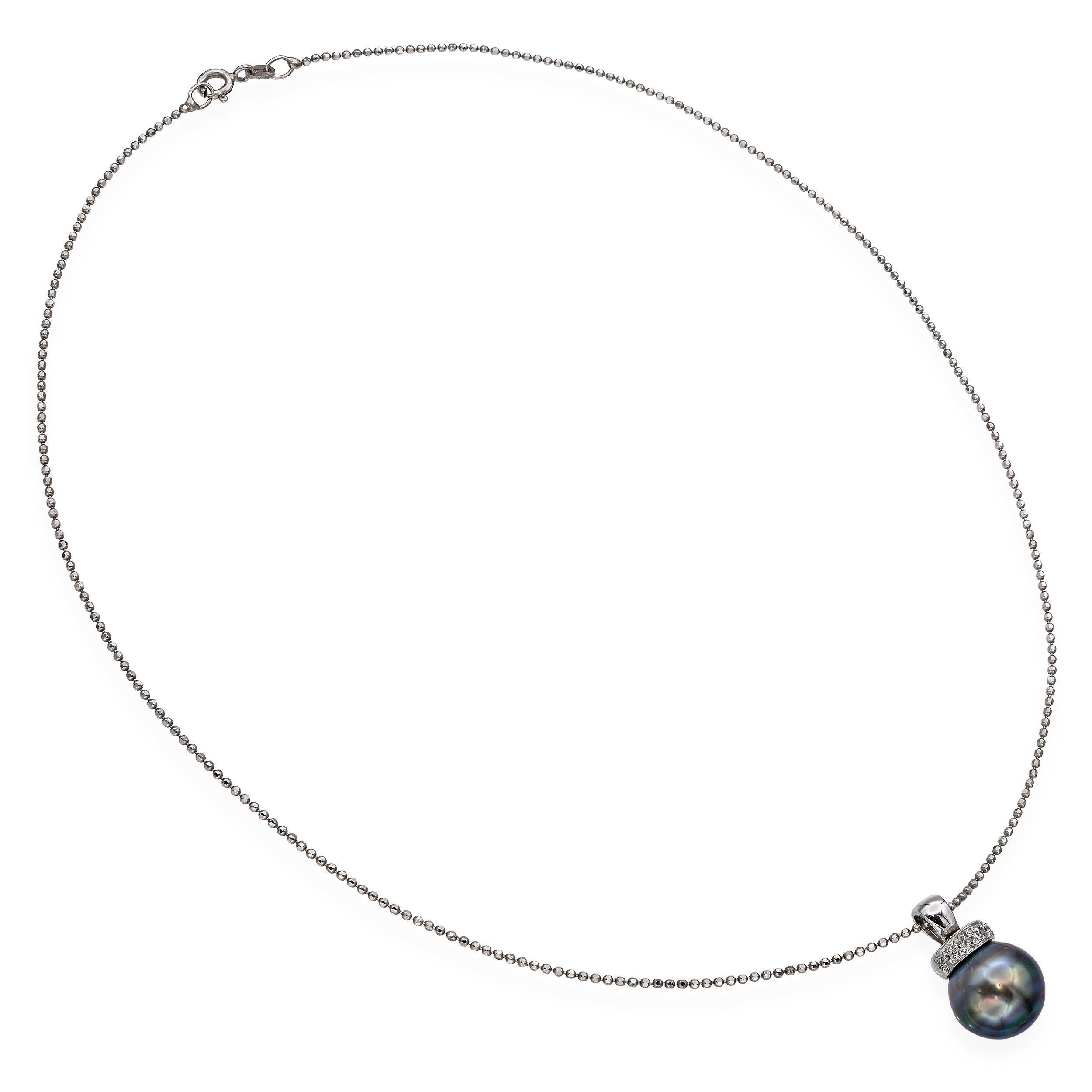 Diese elegante Halskette besteht aus einer schimmernden Tahiti-Perle, die an einem Anhänger aus Weißgold hängt, der mit funkelnden Diamanten besetzt ist. Die Perle hat eine dunkelgrün-graue bis blaugraue Körperfarbe und einen rosa bis violetten