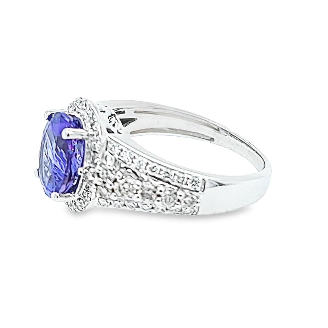 14 Karat White Gold Halo Ring Featuring A 2.01 Carat Oval Cut Tanzanite Accented By 66 Round Brilliant Cut Diamonds of VS Clarity and Contrasting Color Totaling 0.60 Carats. Finger Size 6.5; Purchase Includes One Sizing Service. Finished Weight Is