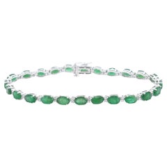 White gold tennis bracelet with diamonds and emerald