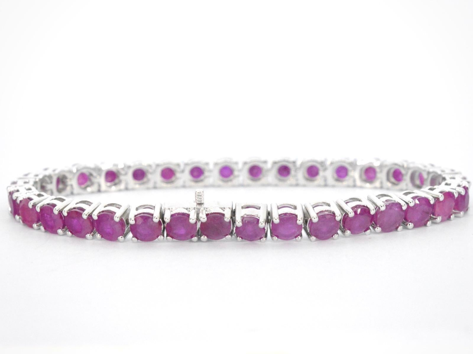 This exquisite white gold tennis bracelet is crafted from 14 karat white gold and features an impressive 17.50 carats of brilliant cut rubies, carefully set along the band for a continuous and dazzling display of colour. The rubies are of high