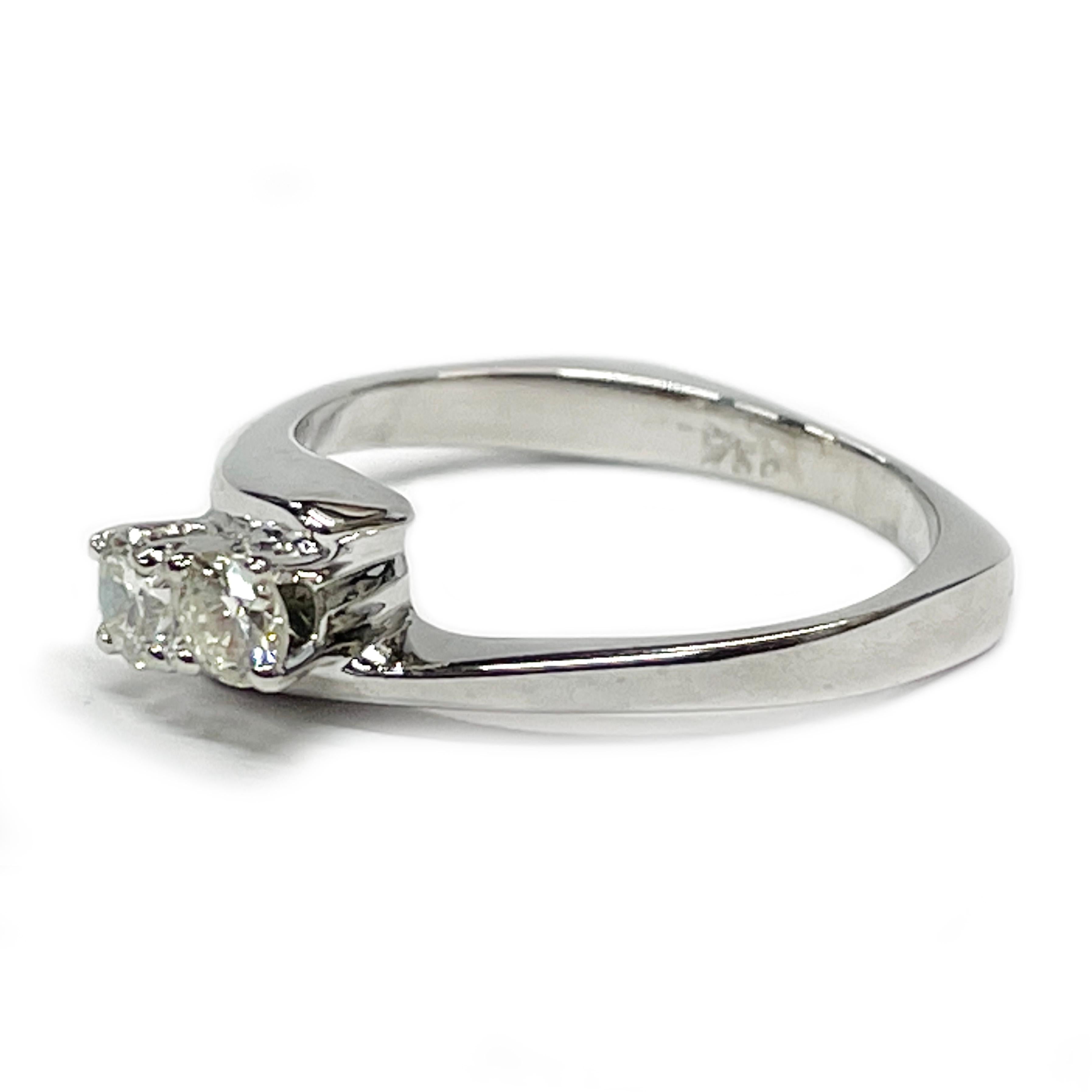 18 Karat White Gold Two Diamond Ring. The ring features two brilliant-cut diamonds set in between a bypass band design. Each diamond measures 3.4mm for an approximate carat weight of 0.30ctw. The diamonds are SI1-SI2 (G.I.A.) in clarity and G-H
