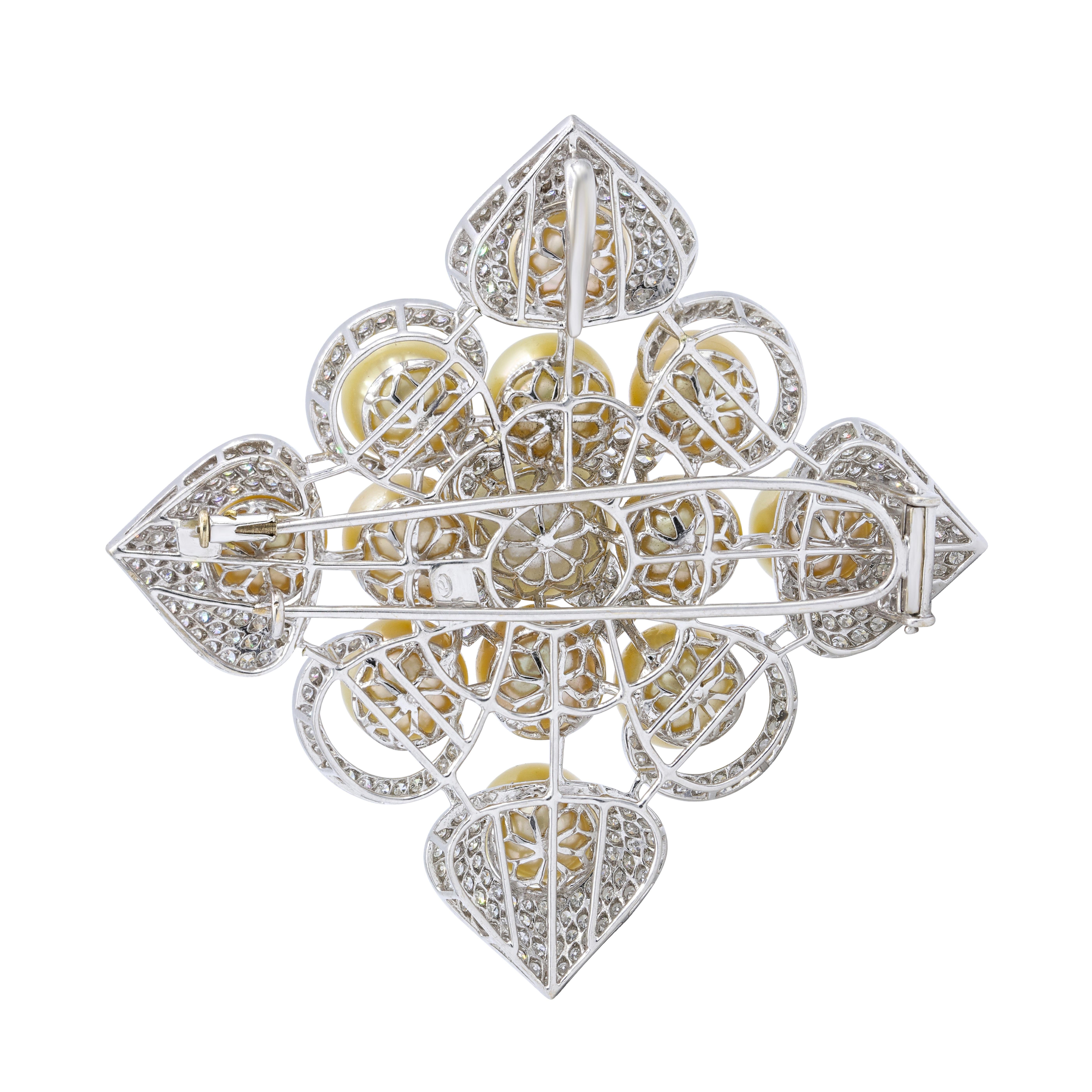 18K white gold pearls and diamonds brooch features 5.00 cts of diamonds and 1 white pearl in the middle and 12 champagne color pearls 11-14mm.