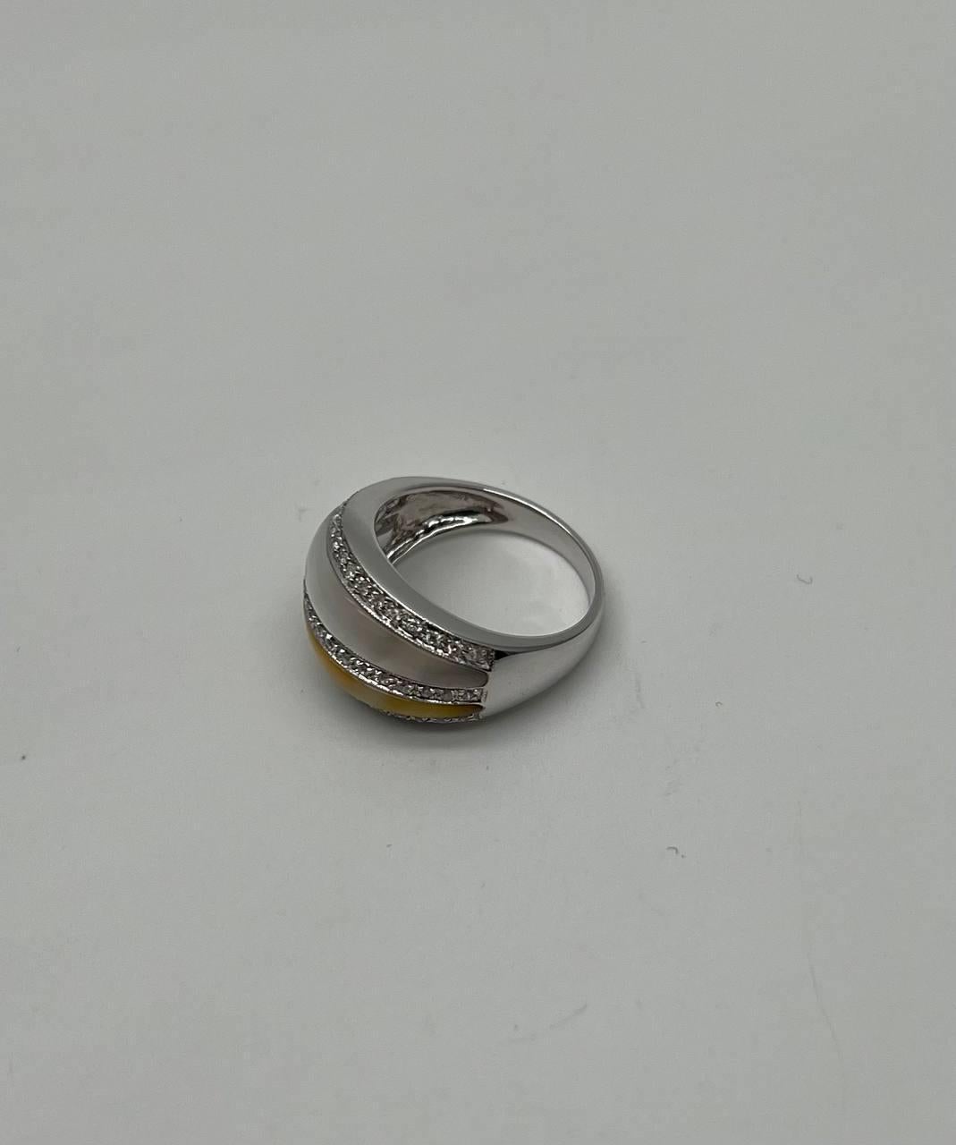A modern and elegant ring featuring a sleek design with two rows of sparkling diamonds.
The ring showcases a smooth, polished surface with a central band of lustrous metal, flanked by the diamond rows.
14K White Gold
White & Golden Mother of Pearl