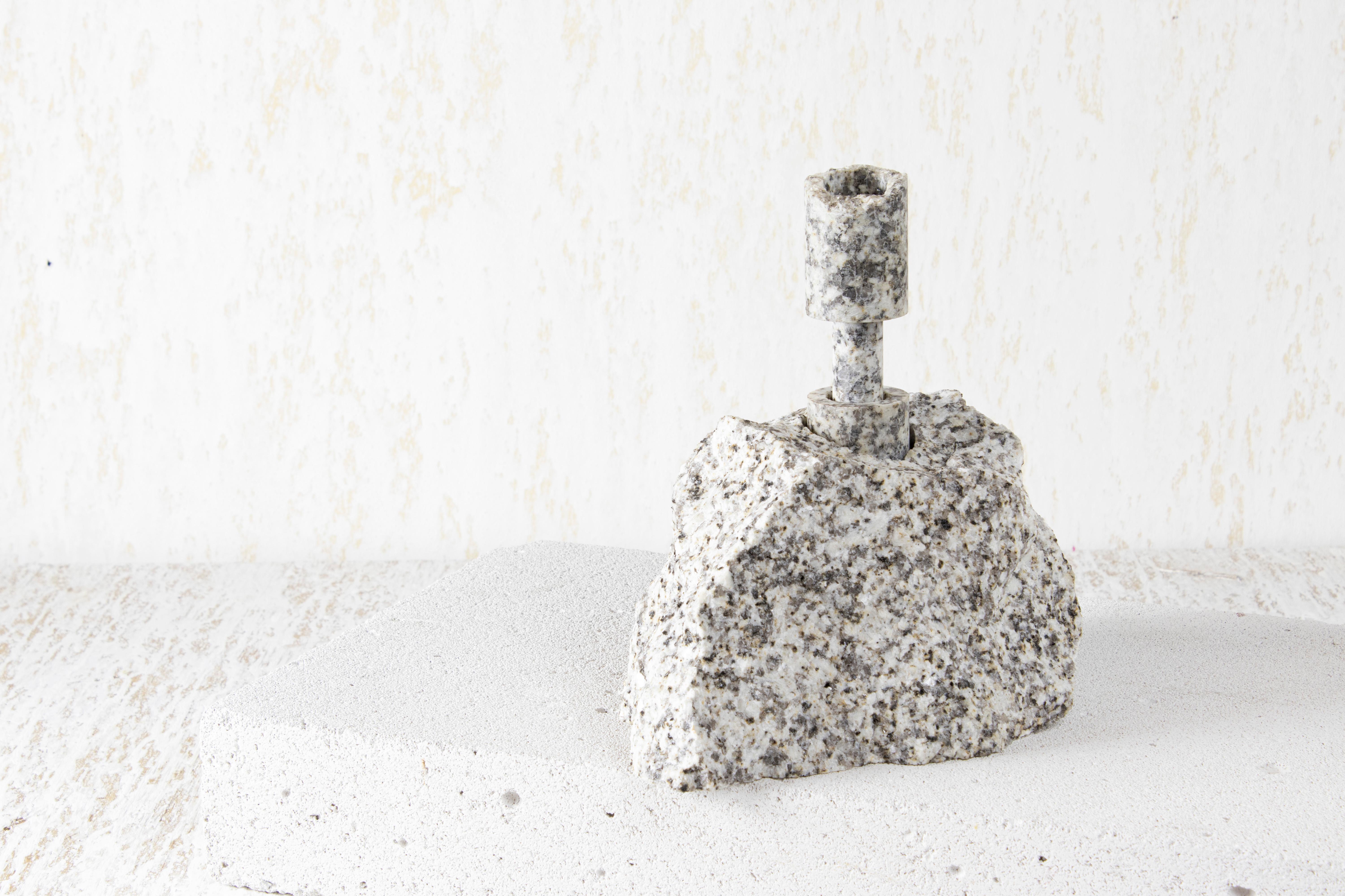 White Granite Abra Candelabra I by Studio DO
Dimensions: D 17 x W 12.5 x H 18 cm
Materials: Granite, aluminum.
3.2 kg.

Stone and fire are connected in an ageless bond. A sparkle created by clashing two stones with each other has been igniting fire
