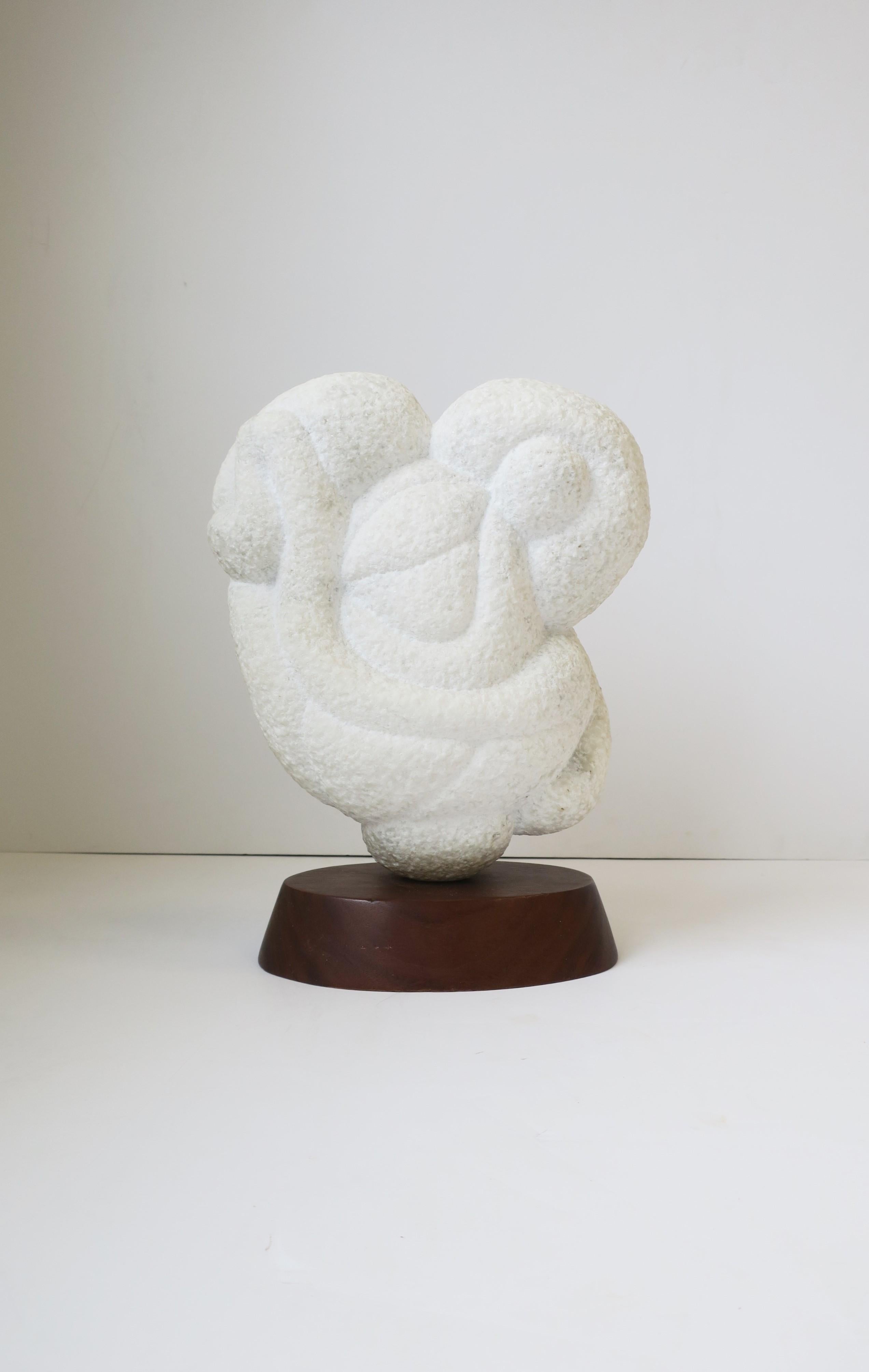 A substantial white granite marble abstract sculpture piece on an oval wood base. Piece measures 13.5
