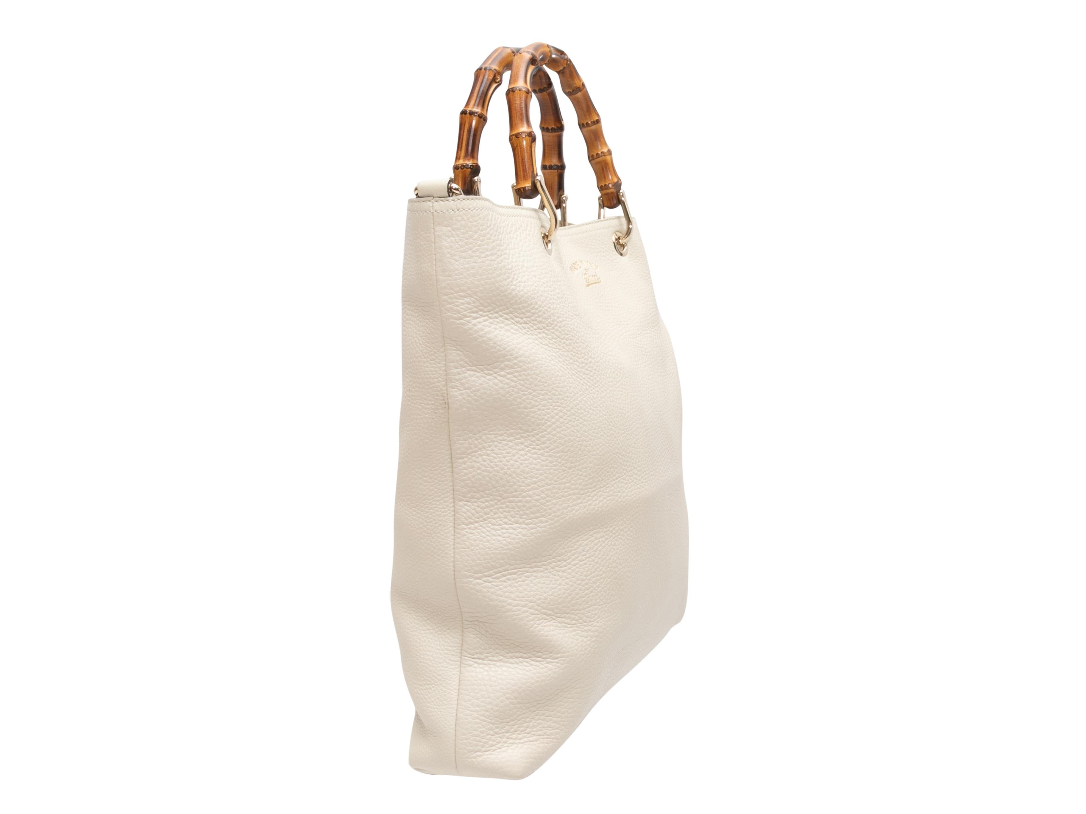 White Gucci Leather & Bamboo Shopping Tote. This shopping tote features a leather body, gold-tone hardware, dual bamboo top handles, and a magnetic top closure. 16