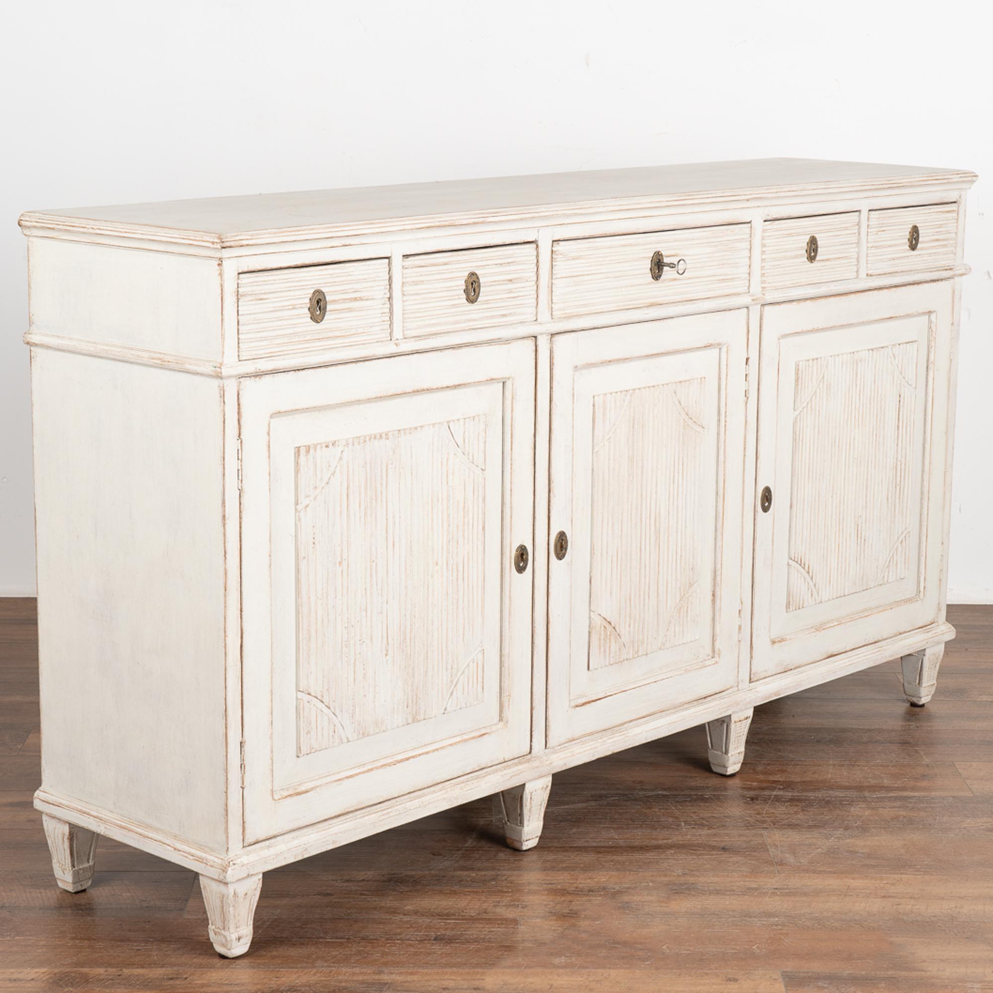 Large pine sideboard with traditional Swedish carved fluted details along panel doors and drawers.
At over 5' long with four cabinet doors and five upper drawers, this will serve as an impressive buffet resting on tapered fluted feet.
Please enlarge