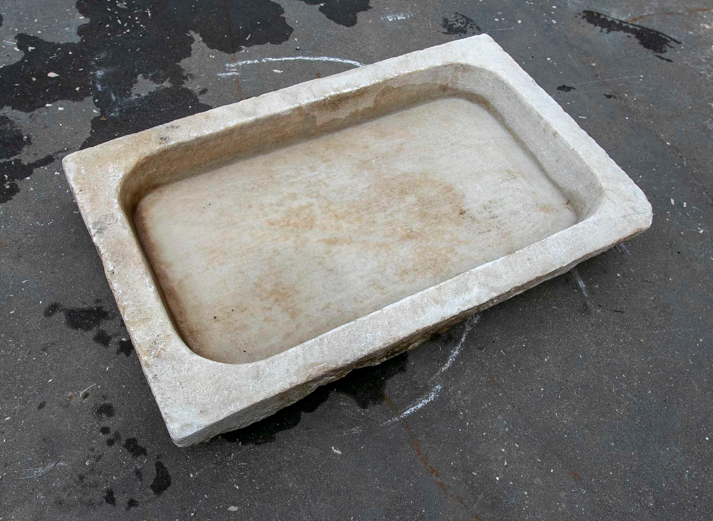 Lavabo en marbre blanc sculpté à la main avec une vasque en un seul bloc.
