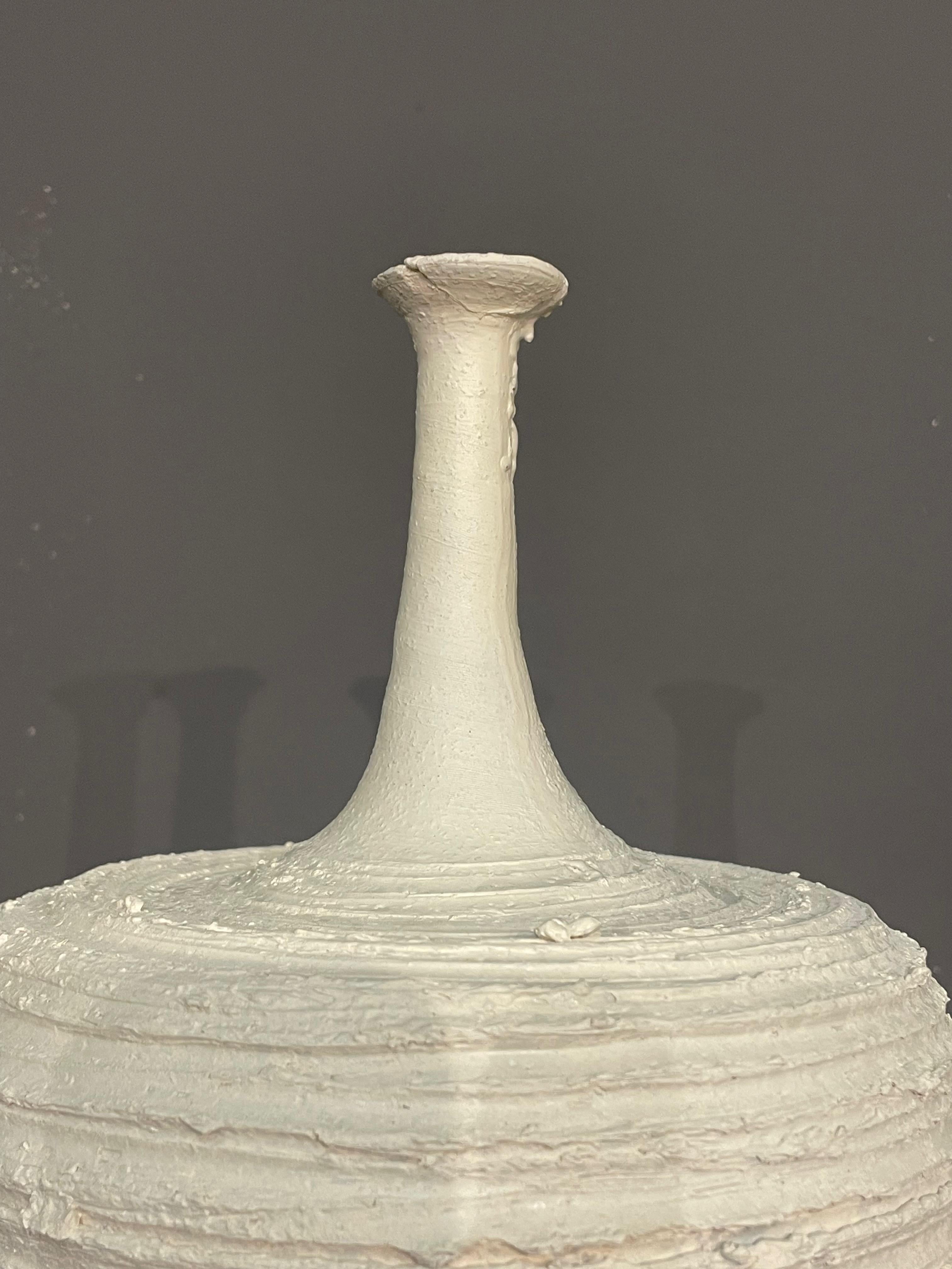 Zeitgenössische, handgefertigte italienische Vase mit brutalistischem Design.
Glatter Hals mit strukturiertem, horizontal geriffeltem Boden.
Teil einer Sammlung von drei Stücken.
