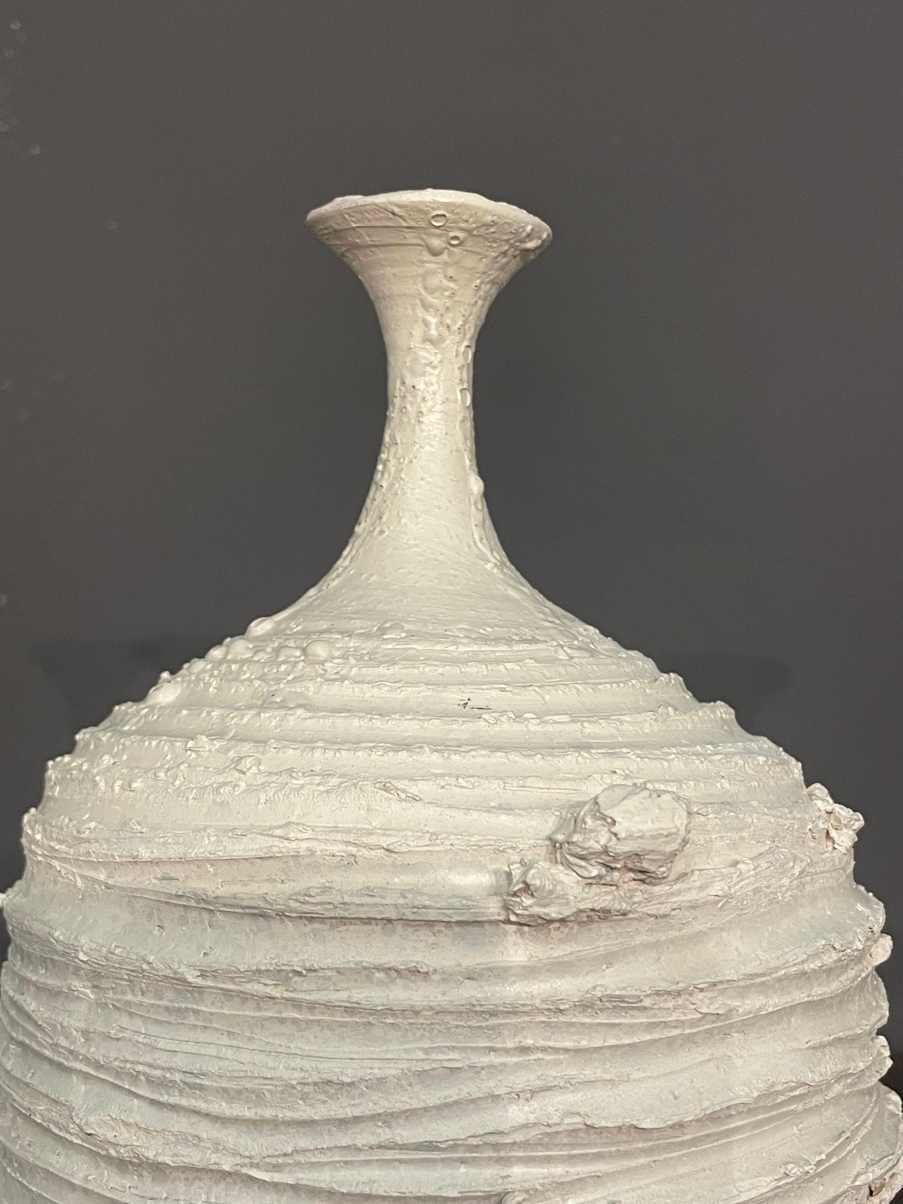 Contemporary Italian hand made Brutalist design white vase.
Smooth neck with rough horizontal ridged base.
Part of a collection of three pieces.
