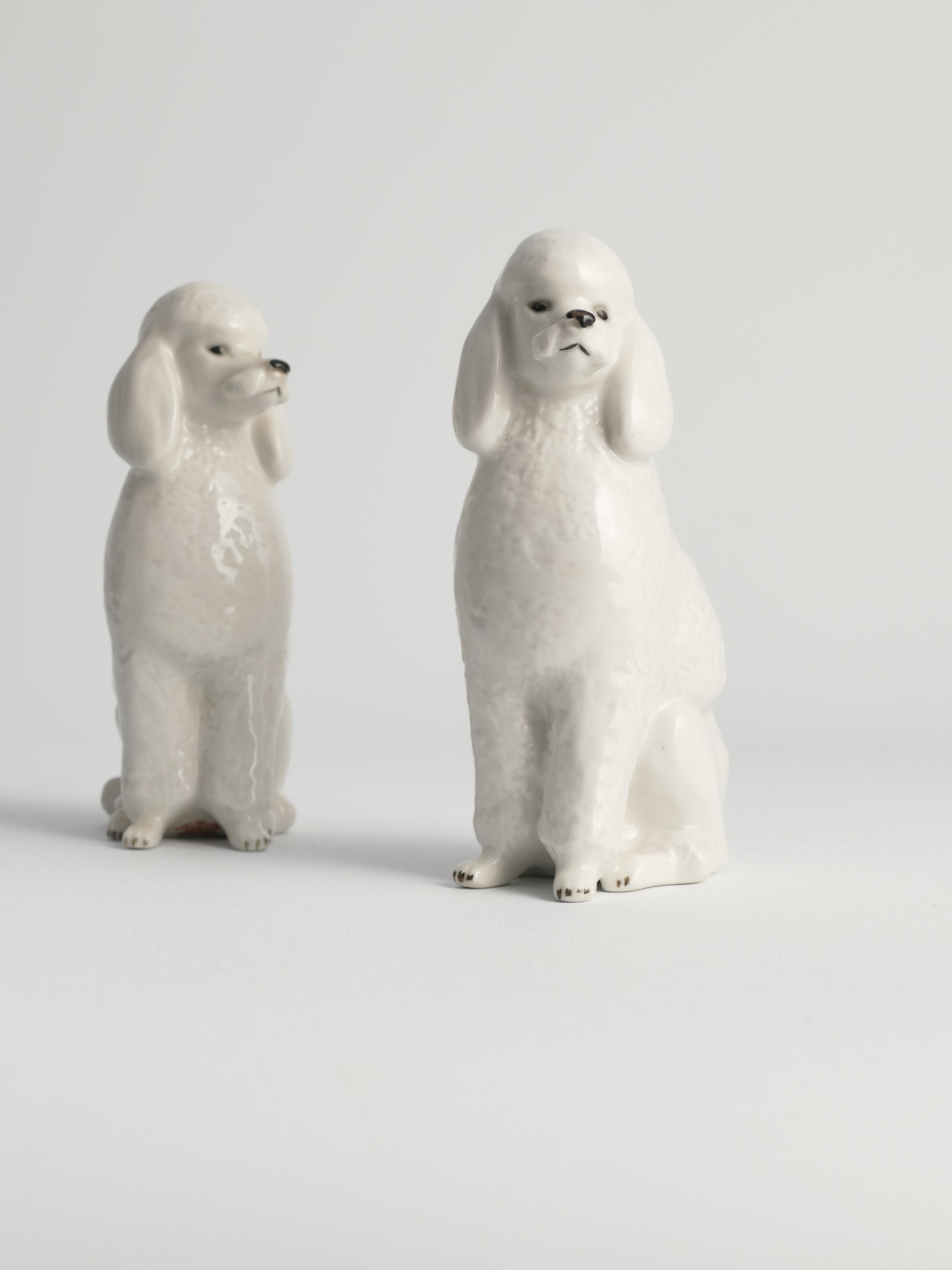 This is an adorable pair of vintage mid-century modern Lomonosov Soviet Imperial Russia hand-painted fine porcelain sitting white poodle dog figurines, dating back to the 1960s.

Crafted from white soft-paste porcelain, these figurines feature