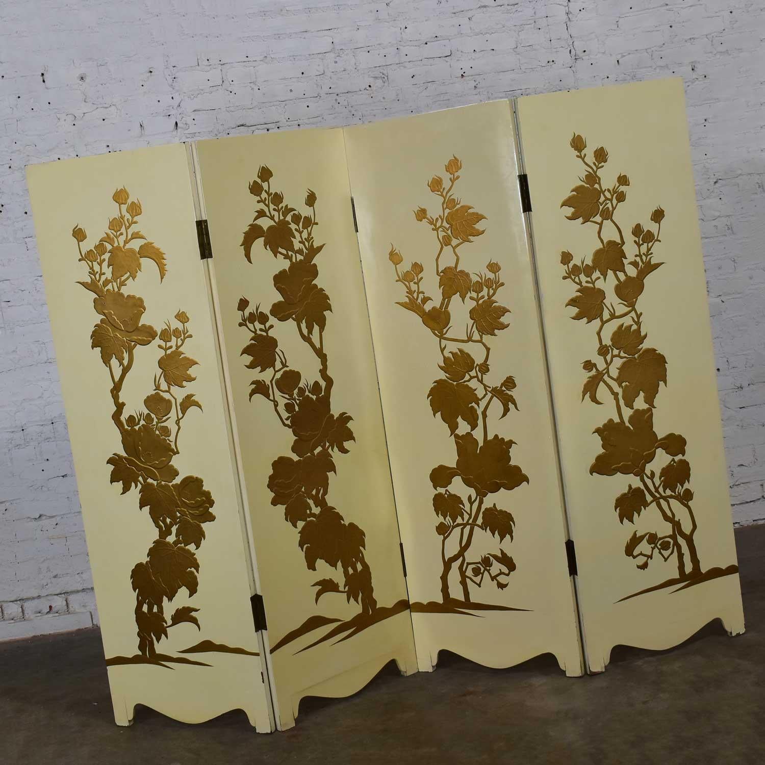 Stunning Hollywood Regency or boho chic four panel folding screen comprised of off-white painted finished wood, embossed textured floral print design on front panels in gold, and brass hinges. Beautiful vintage condition with just some minor touch