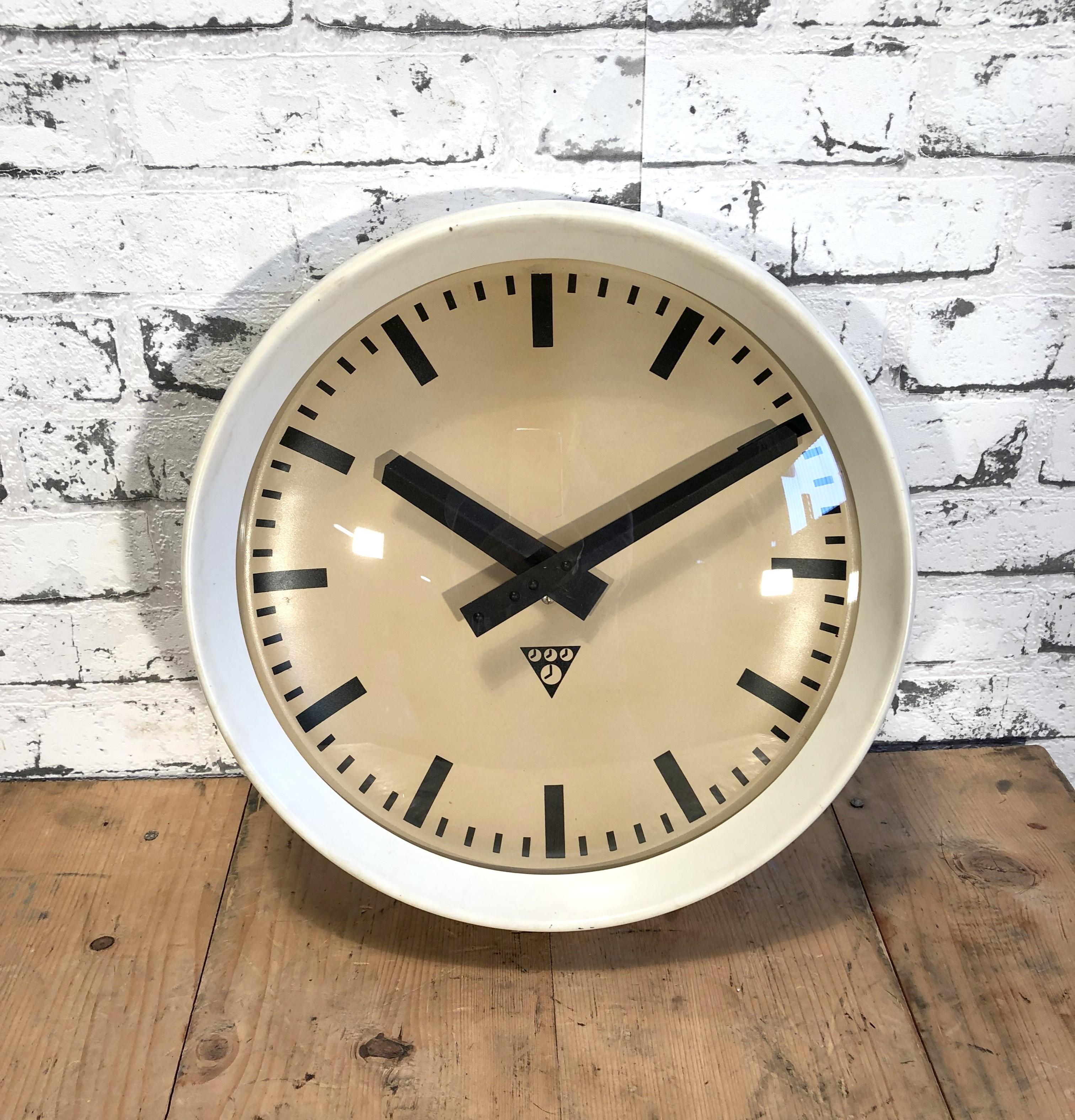 This wall clock was produced by Pragotron in former Czechoslovakia during the 1960s.It features a white bakelite frame, aluminium dial and clear glass cover. The piece has been converted into a battery-powered clockwork and requires only one