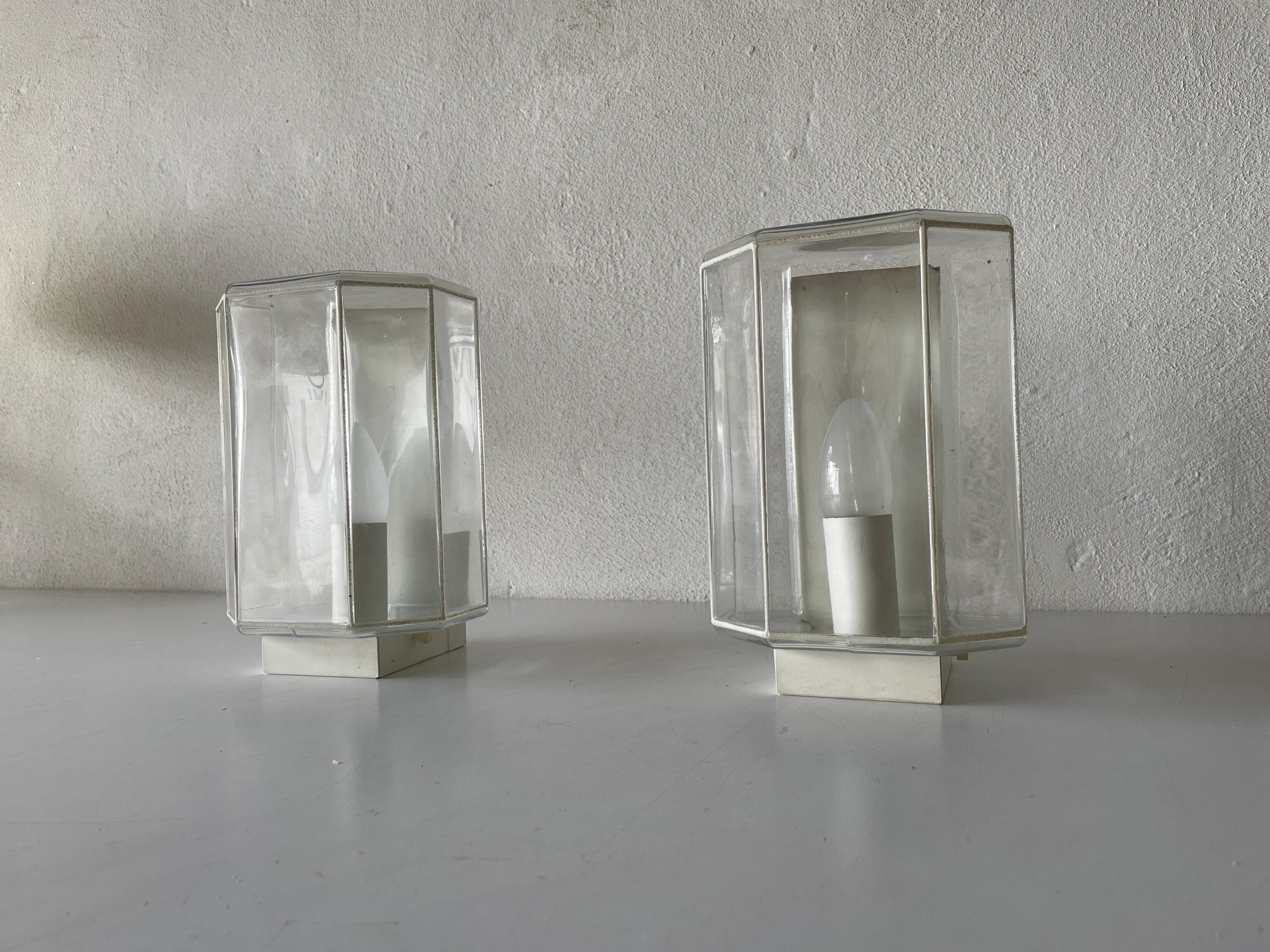 White Iron Structured Glass Pair of Sconces, 1960s, Limburg, Germany

Very elegant and minimal design wall lamps
Lamp is in very good condition.

These lamps works with E14 standard light bulbs. 
Wired and suitable to use in all countries.