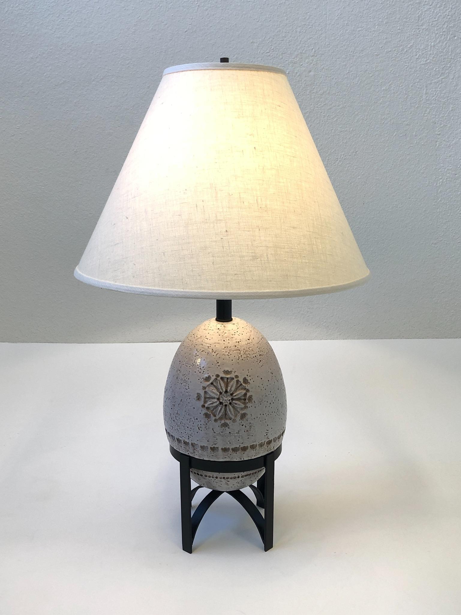 1960s Italian white glazed ceramic table lamp by Bitossi.
The lamp is constructed of white glazed egg shape ceramic that sits on a black lacquered steel base.
Newly rewired and new vanilla linen shade.
Overall dimensions with shade: 30” high, 18”