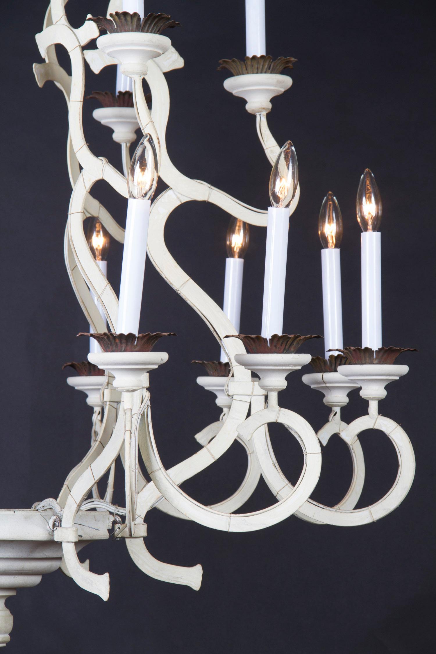 This painted  Italian chandelier features iron arms, tole and wooden bobeches, and a wooden finial at top and bottom. The piece dates back to the mid 20th century, features simple ‘flat body’ arms, with two tiers of lighting.

Each piece in our shop