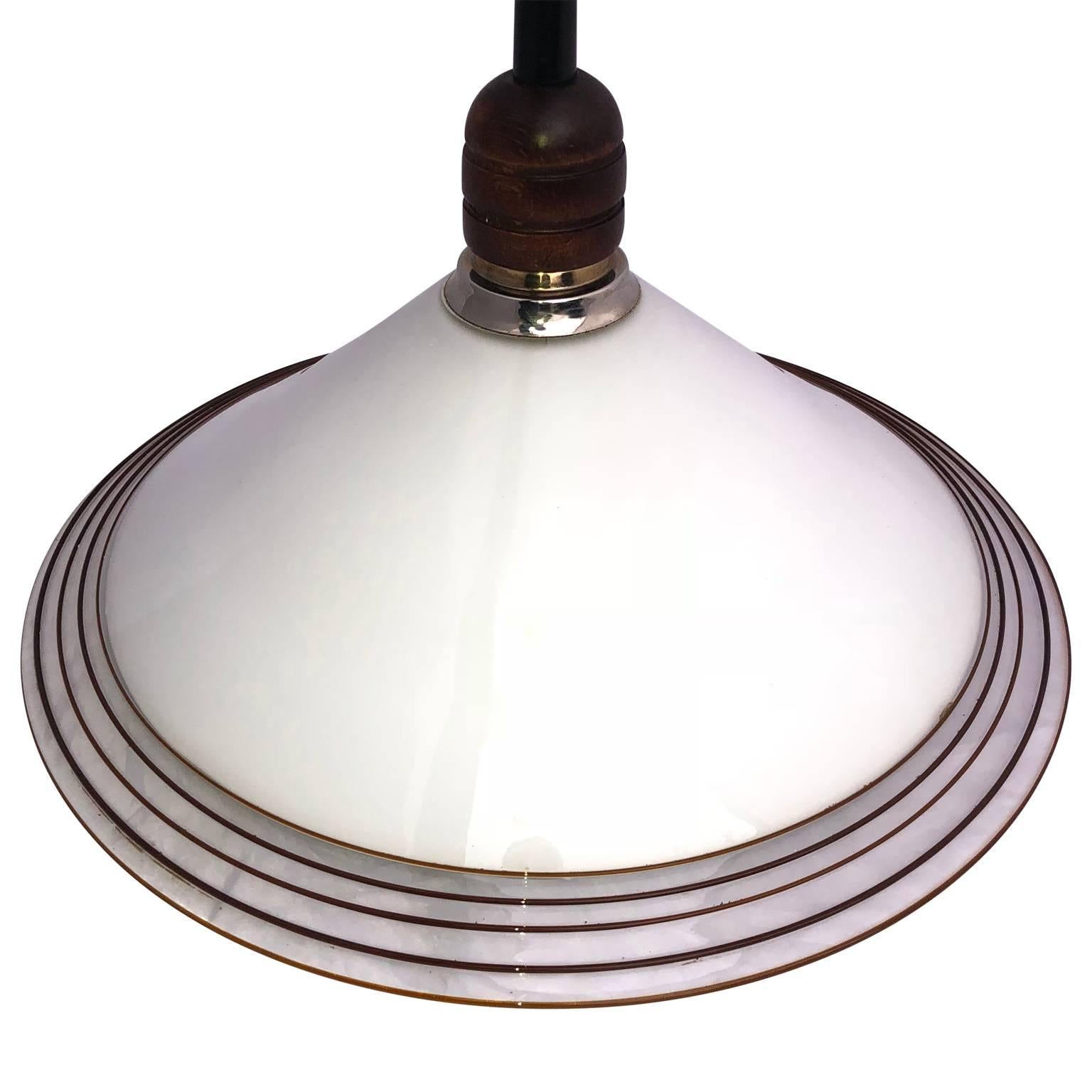 White Italian Murano art glass dish shape swirl pendant light

The white dish design is decorated with dark amber colored swirl. The glass dish has chrome and wood hardware. Newly re-wired.

     