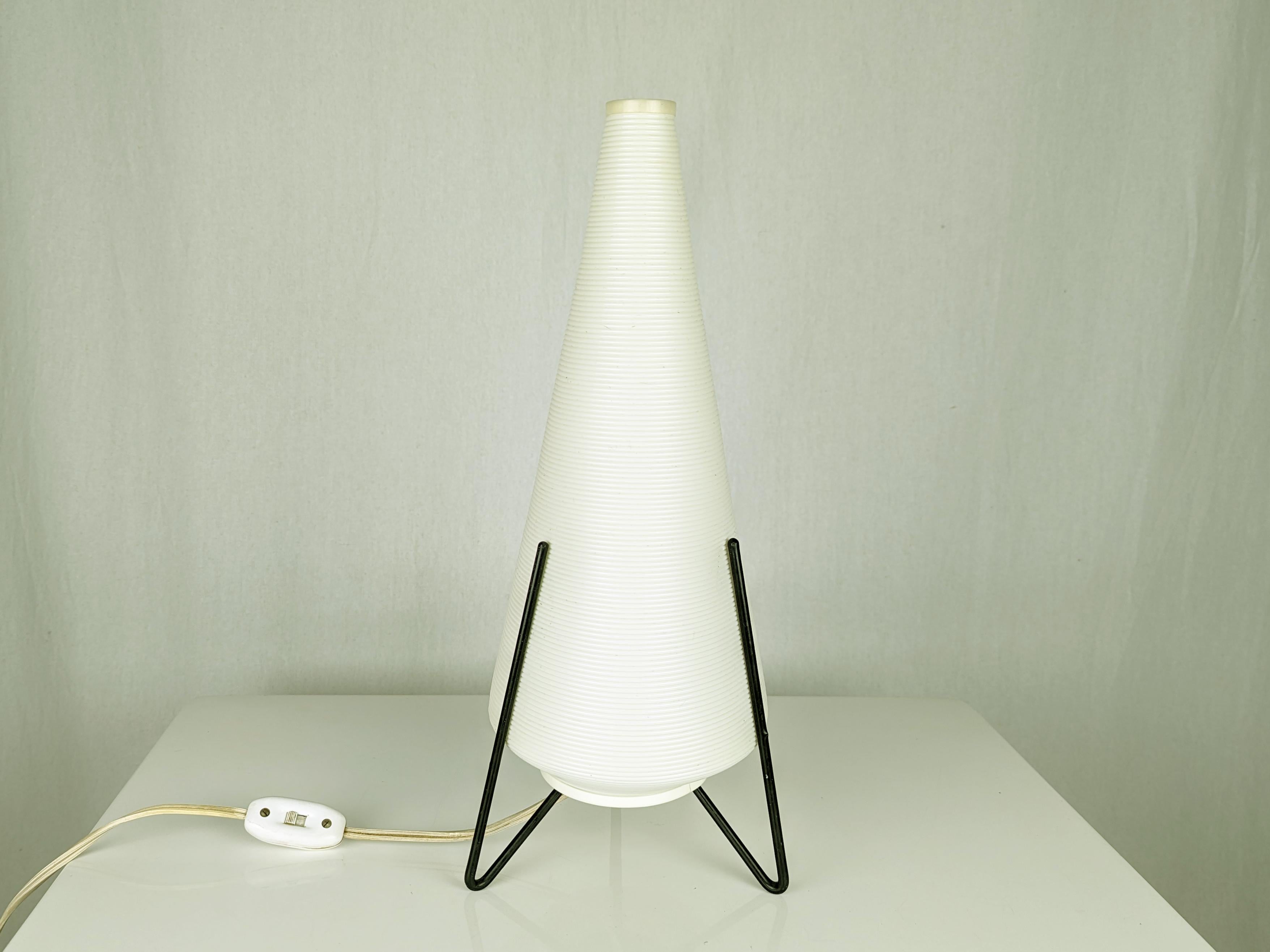 Small table lamp in white/ivory plastic shade and black metal rod structure. Good condition.