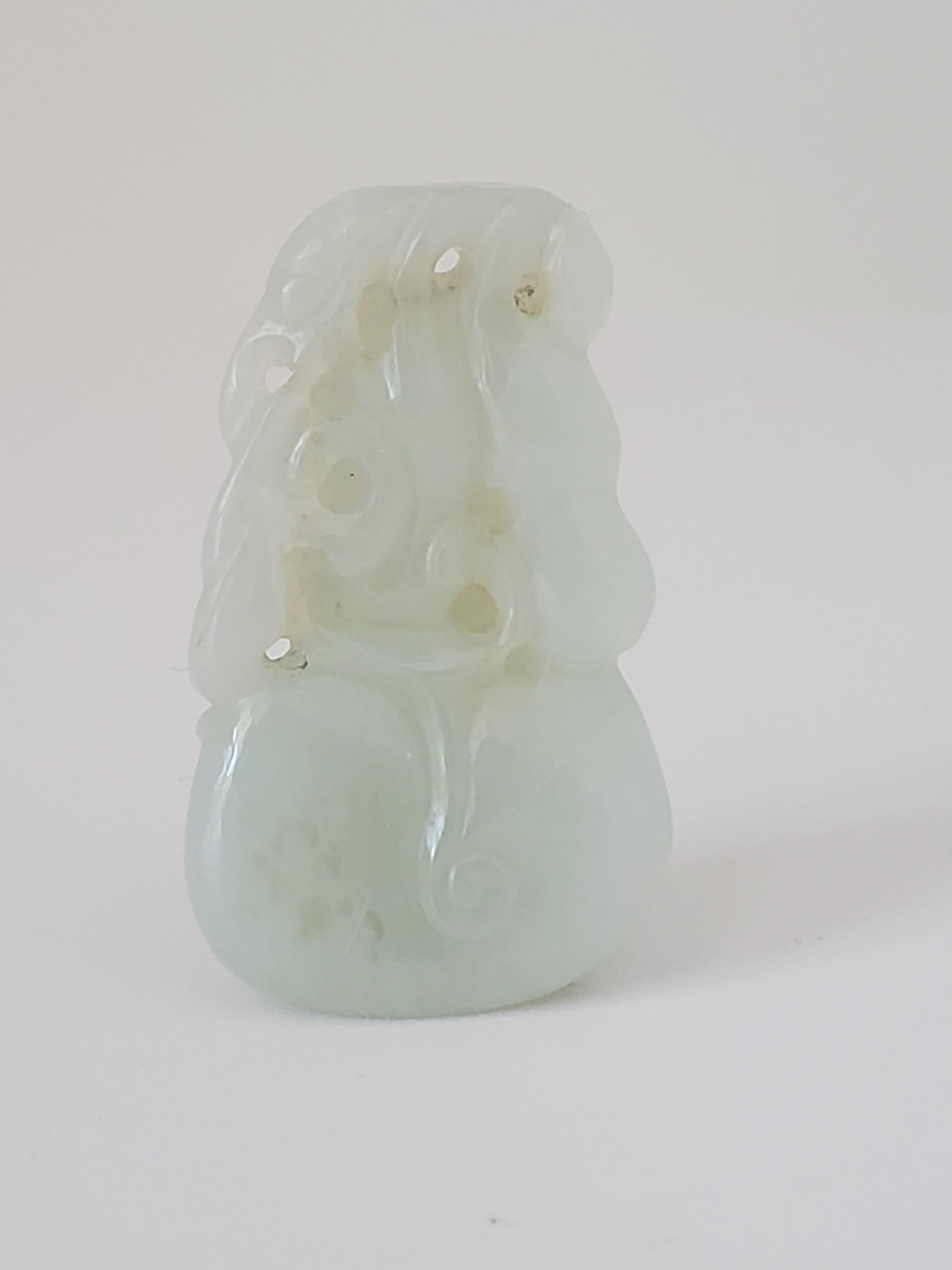 This antique nephrite jade double gourd pendant is of the Qing Dynasty and has a fine texture with a glossy luster. It is primarily white with some slight inclusions in the left lower body but in bright light the pendant has a slight green tinge.