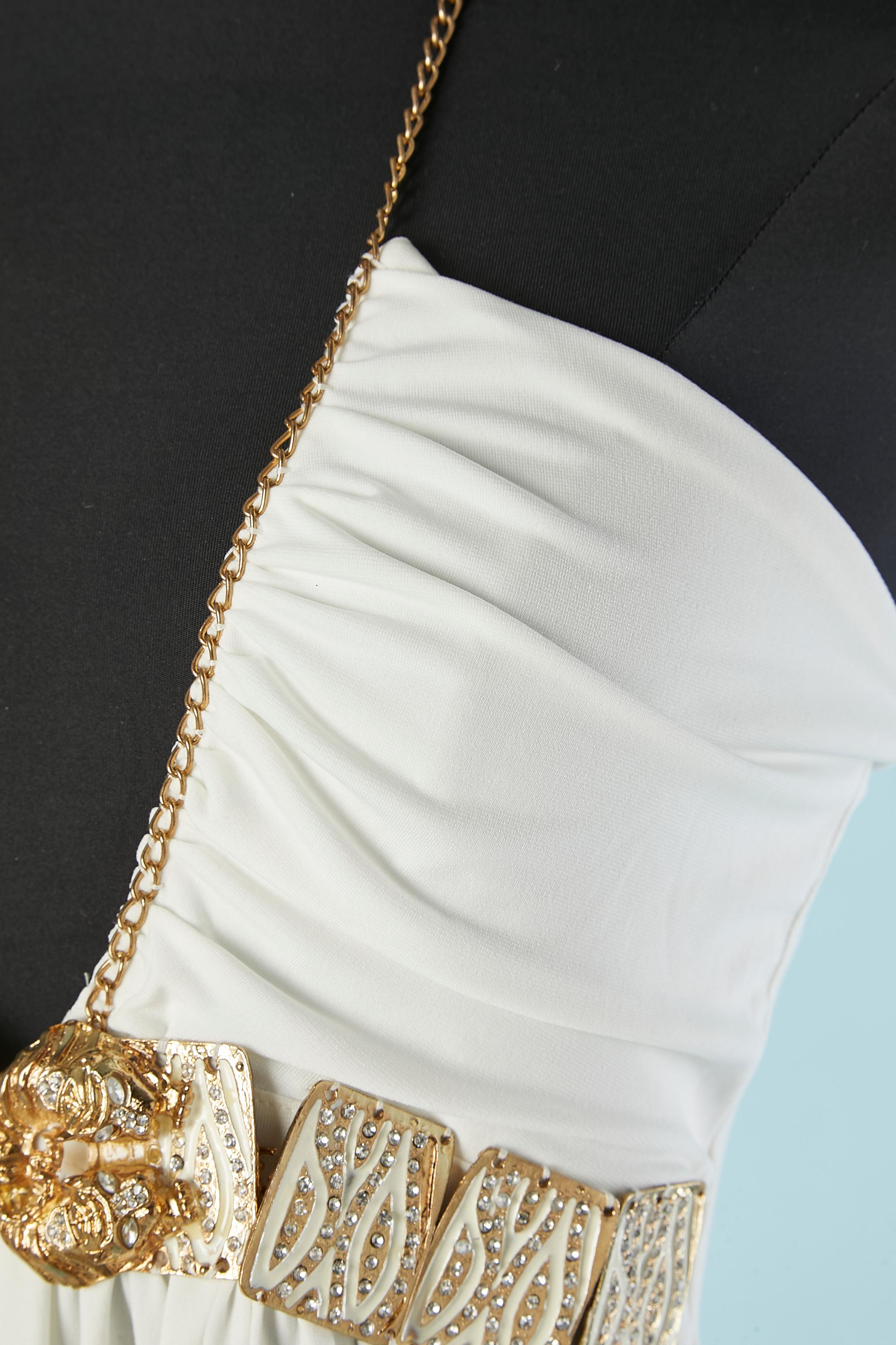 Vestido de cóctel de punto blanco con medio cinturón de metal dorado y pedrería. Composición del tejido: 95% rayón, 5% licra .Sin espalda. Cadena en el escote. Sujétala con un lazo detrás del cuello. NUEVO CON ETIQUETA. Holograma de