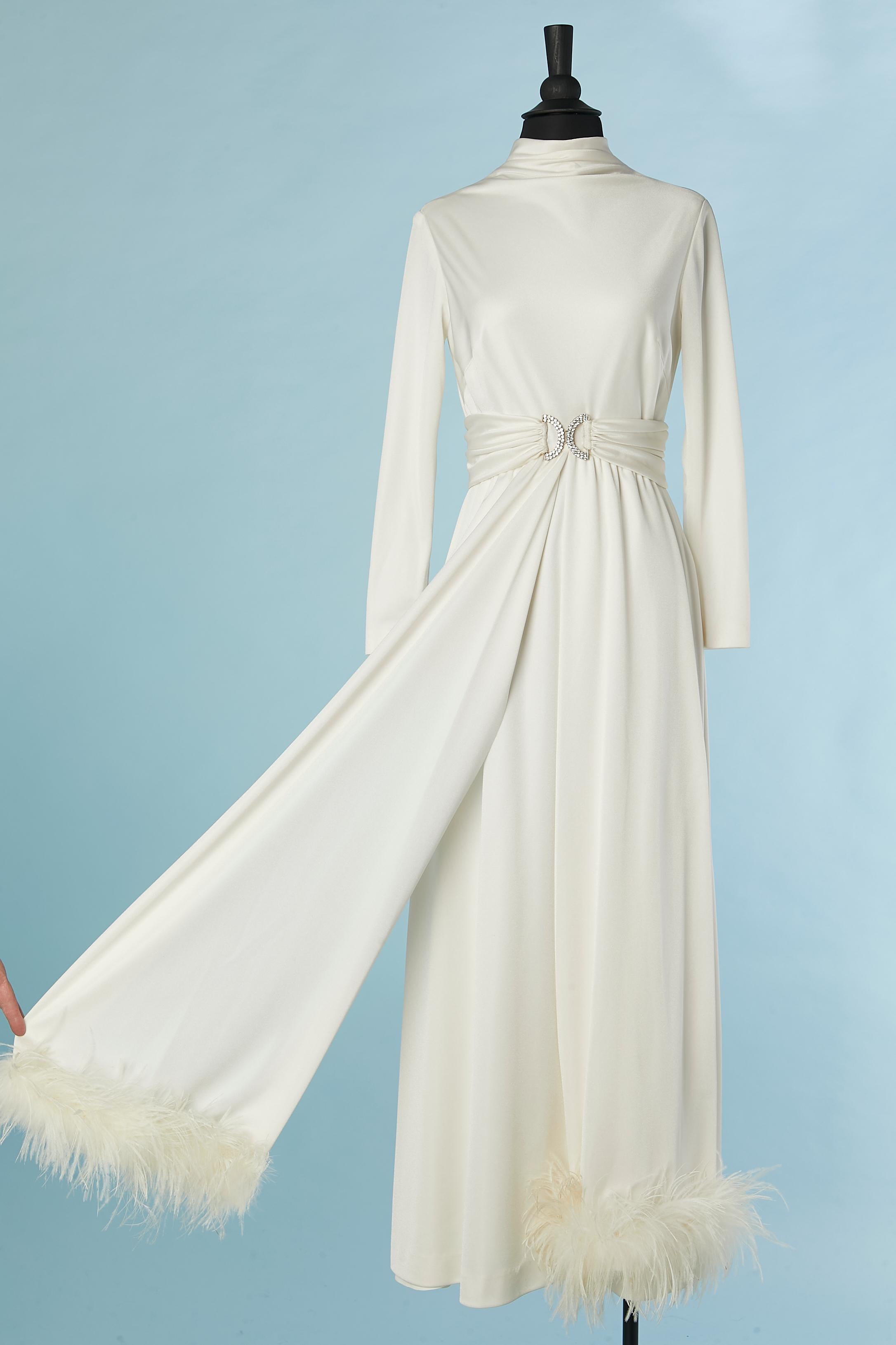 White jersey evening dress with rhinestone belt buckle and white feather edge. No fabric composition tag but probably polyester jersey. Zip closure and hook&eye on the middle back. 
Small weight inside the collar on the top middle front to keep the