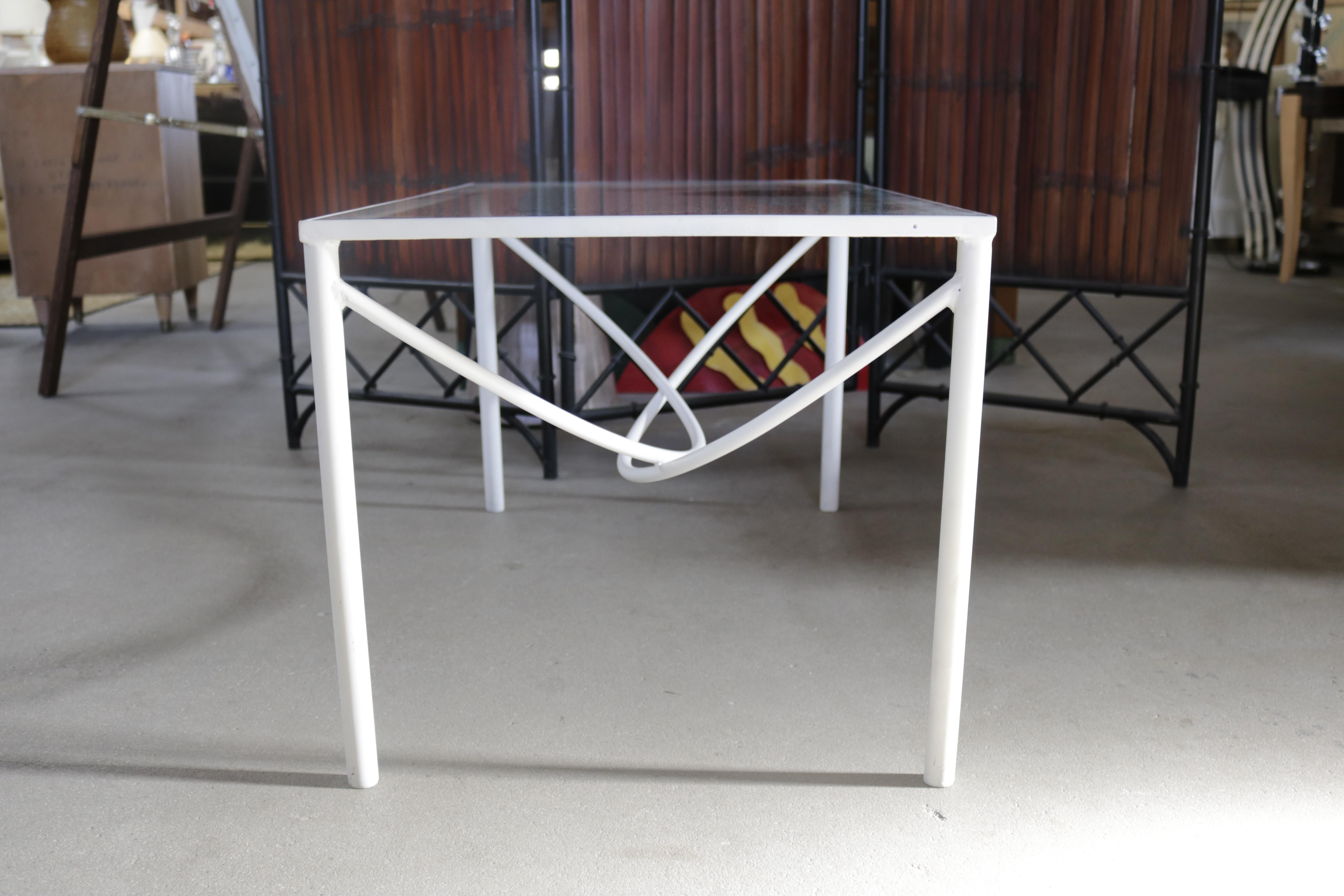Elegant, bent steel coffee table in white lacquer with an inset glass surface. The table's central support is composed of two half circles creating an eye-catching, architectural design.