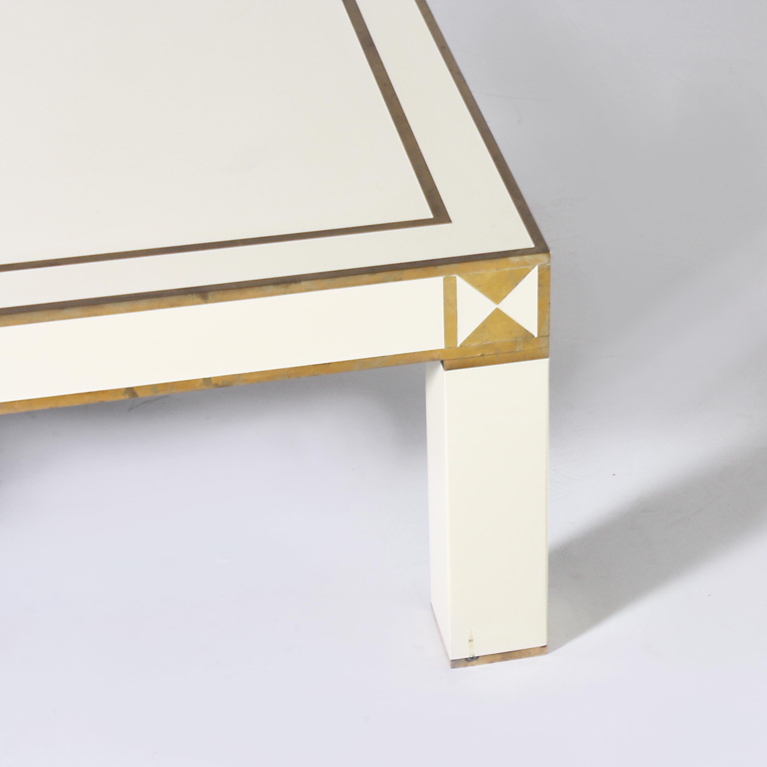 White lacquer coffee table with brass details, circa 1950.