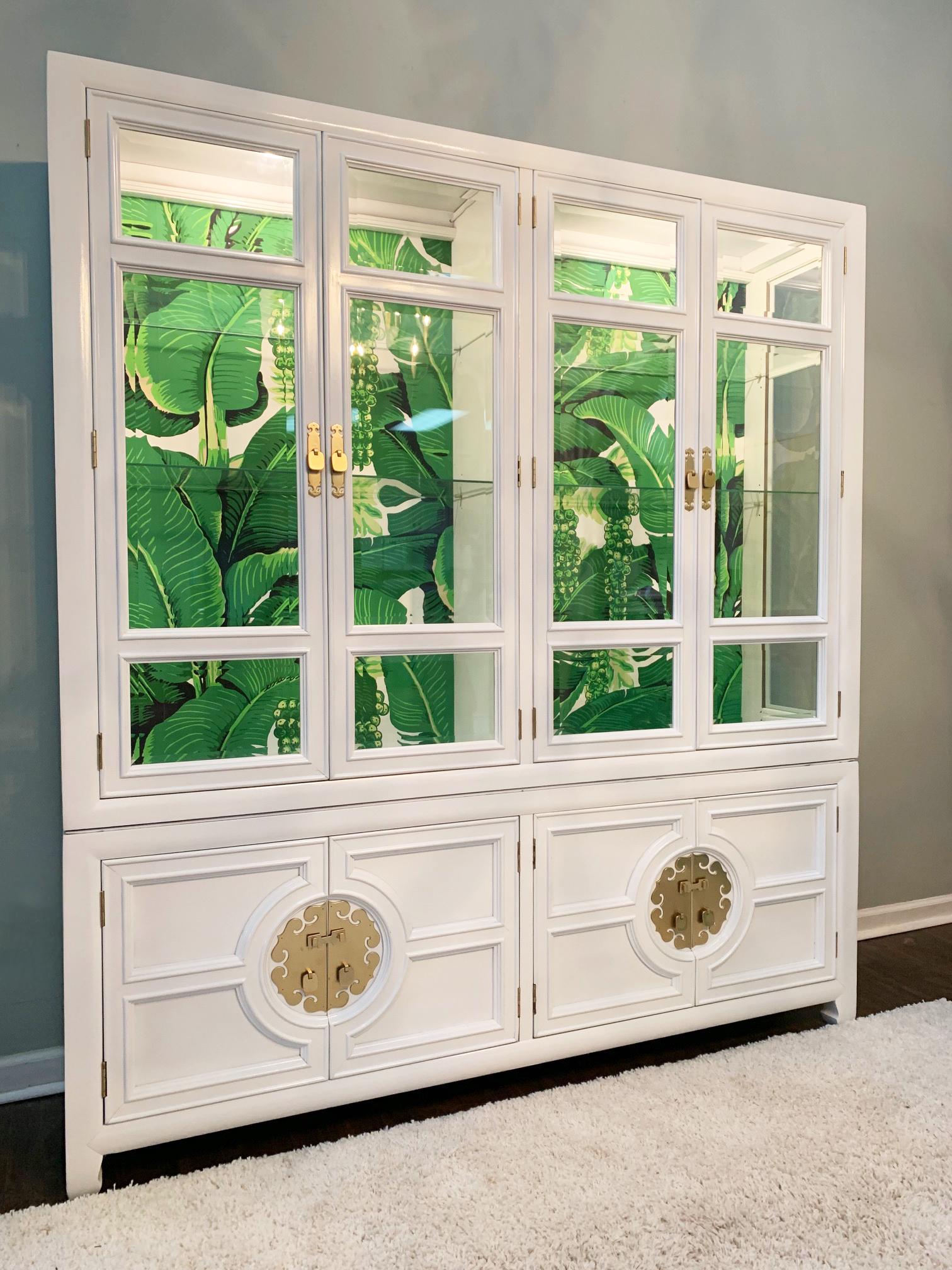 Large china cabinet by Century Furniture features new high gloss white lacquer finish, Dorothy Draper Brazilliance wallpaper detailing, and beveled glass doors. Lower cabinet sits on Ming styled legs and houses three drawers and shelving for