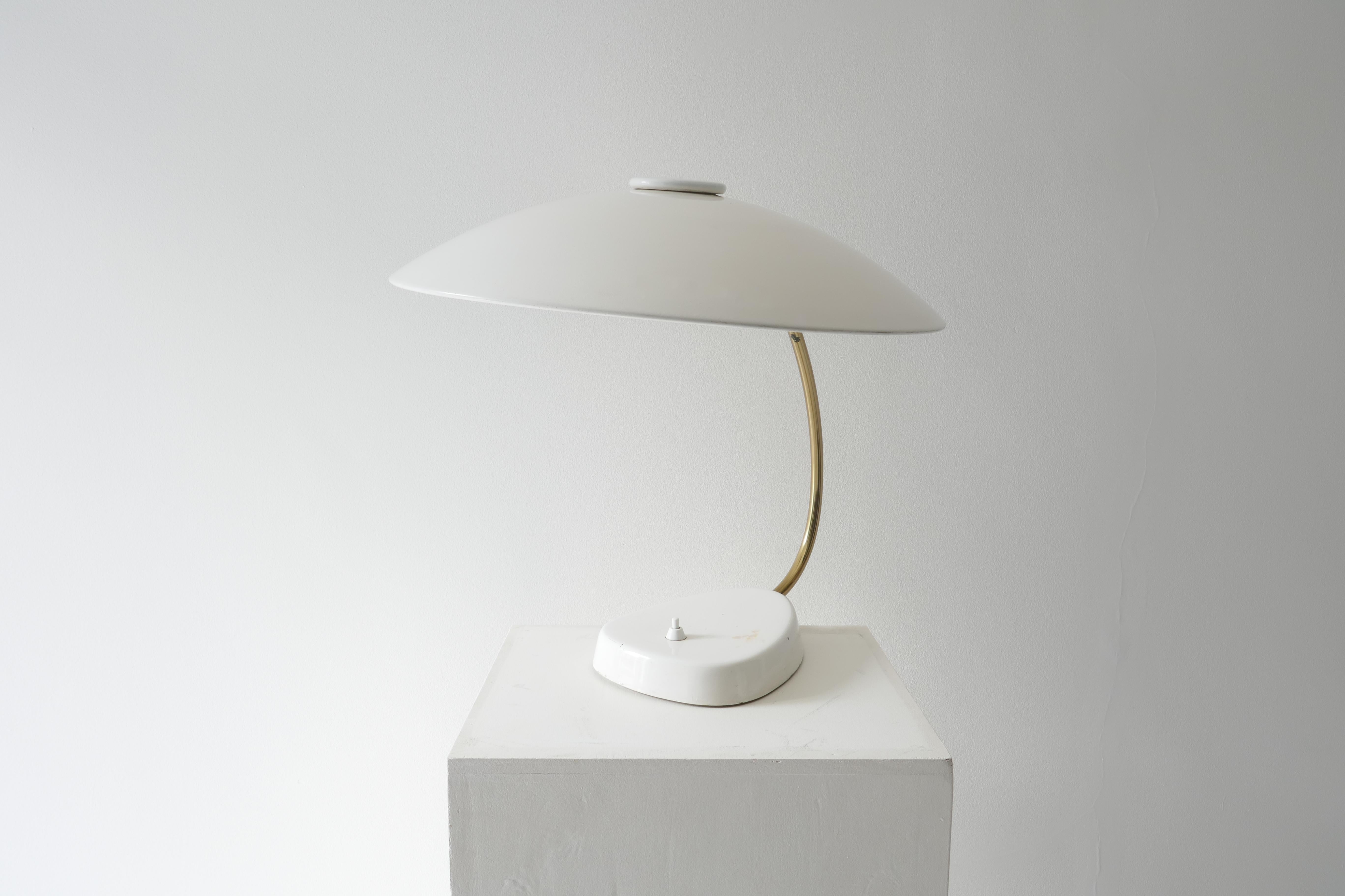 A lovely white lacquered and brass table lamp with a 42 cm saucer like shade.
The shade provides a smooth wide light.
Measures: L 42 x H 42cm
Germany 1960s.