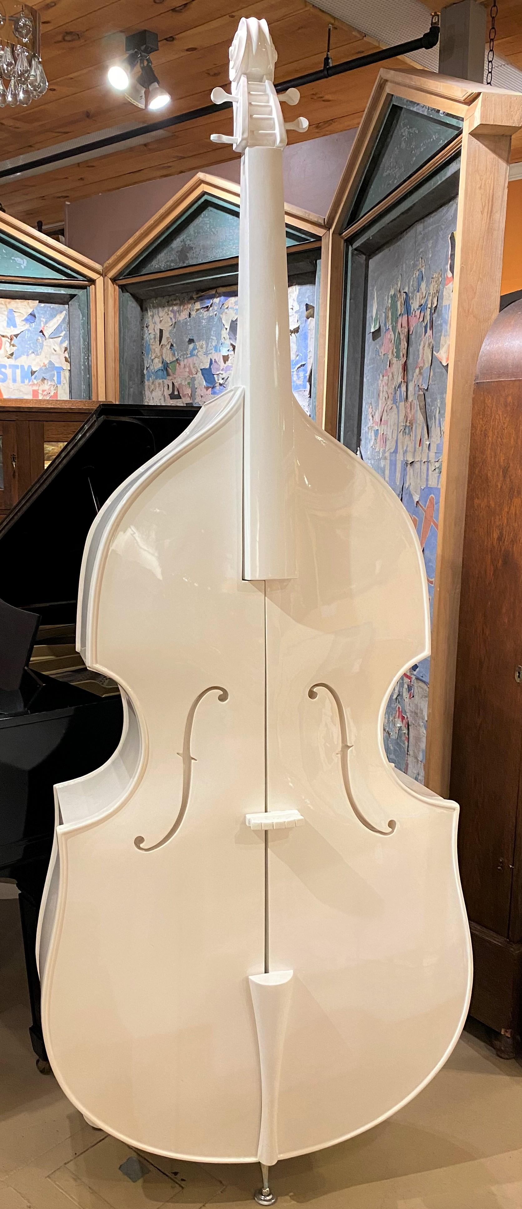 A wonderful modern double base or cello form white lacquered cabinet which slides open from the center to reveal three hidden interior shelves, supported by a front metal foot and two rear wooden feet. Dates to the the late 20th century and is in