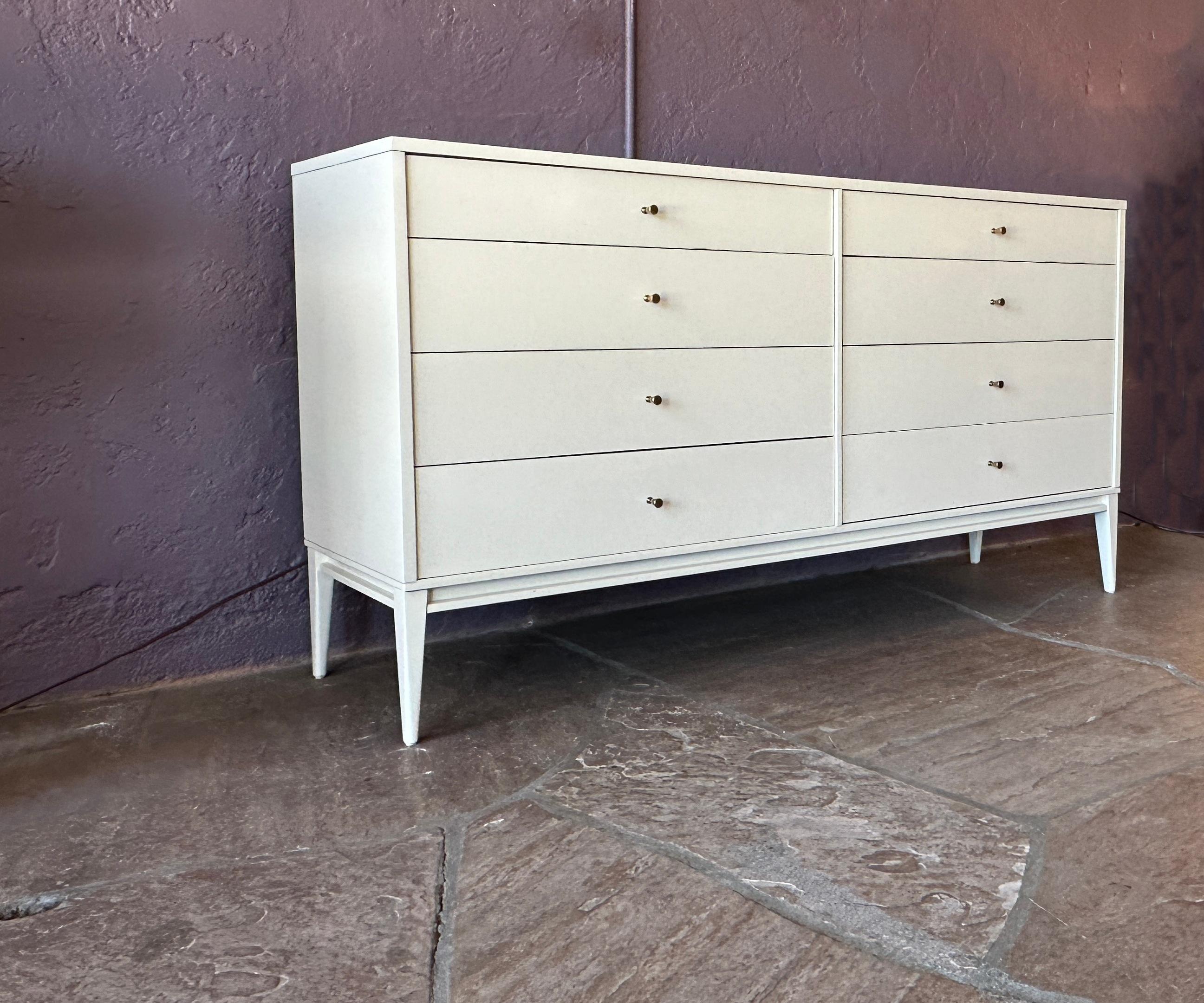 This elegant white lacquer Paul McCobb dresser features 8 drawers with simple chromed knobs.
