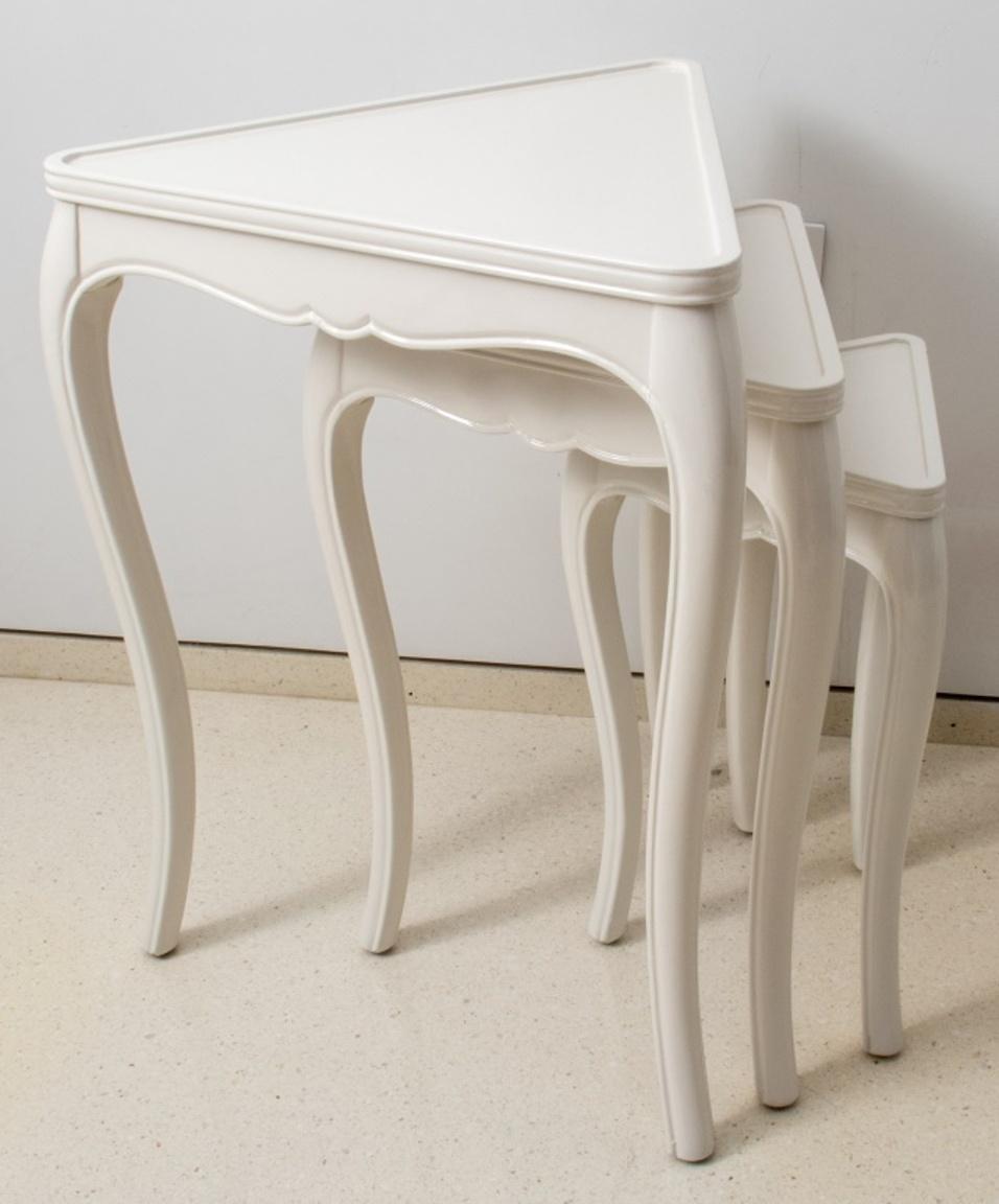 White lacquered triangular nesting tables, with molded banded edges above a shaped apron, each on three cabriole legs. 27