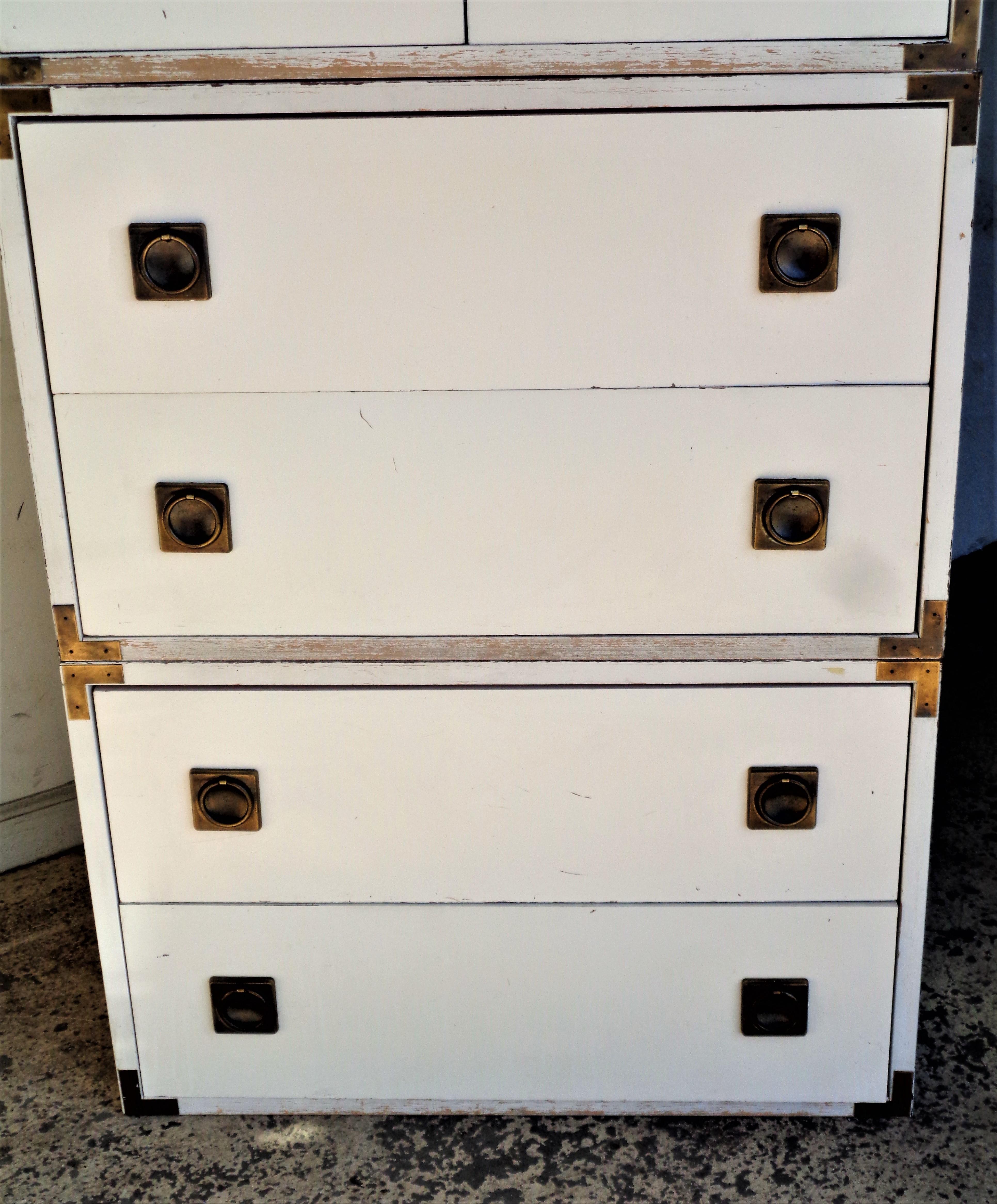 Three tiered campaign style white laminate and wood tall chest with nice brass hardware. As photographed showing two sets of stacking lower double drawers at bottom and a stacking two door cabinet with open interior at top. All sections are the same