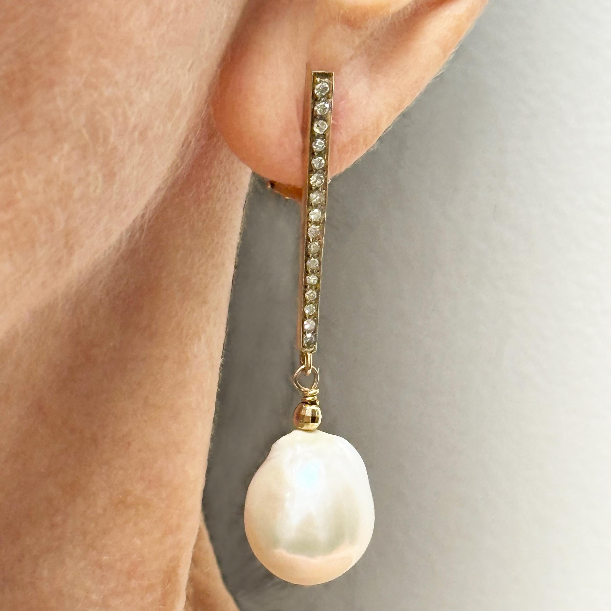 Beschreibung
Diese großen, glänzenden Perlen, die an einem zarten Pavé-Diamantstab aufgehängt sind, verbinden nahtlos klassische Schönheit mit modernem Charme. Die funkelnden Diamanten fangen bei jeder Bewegung das Licht ein und verstärken den