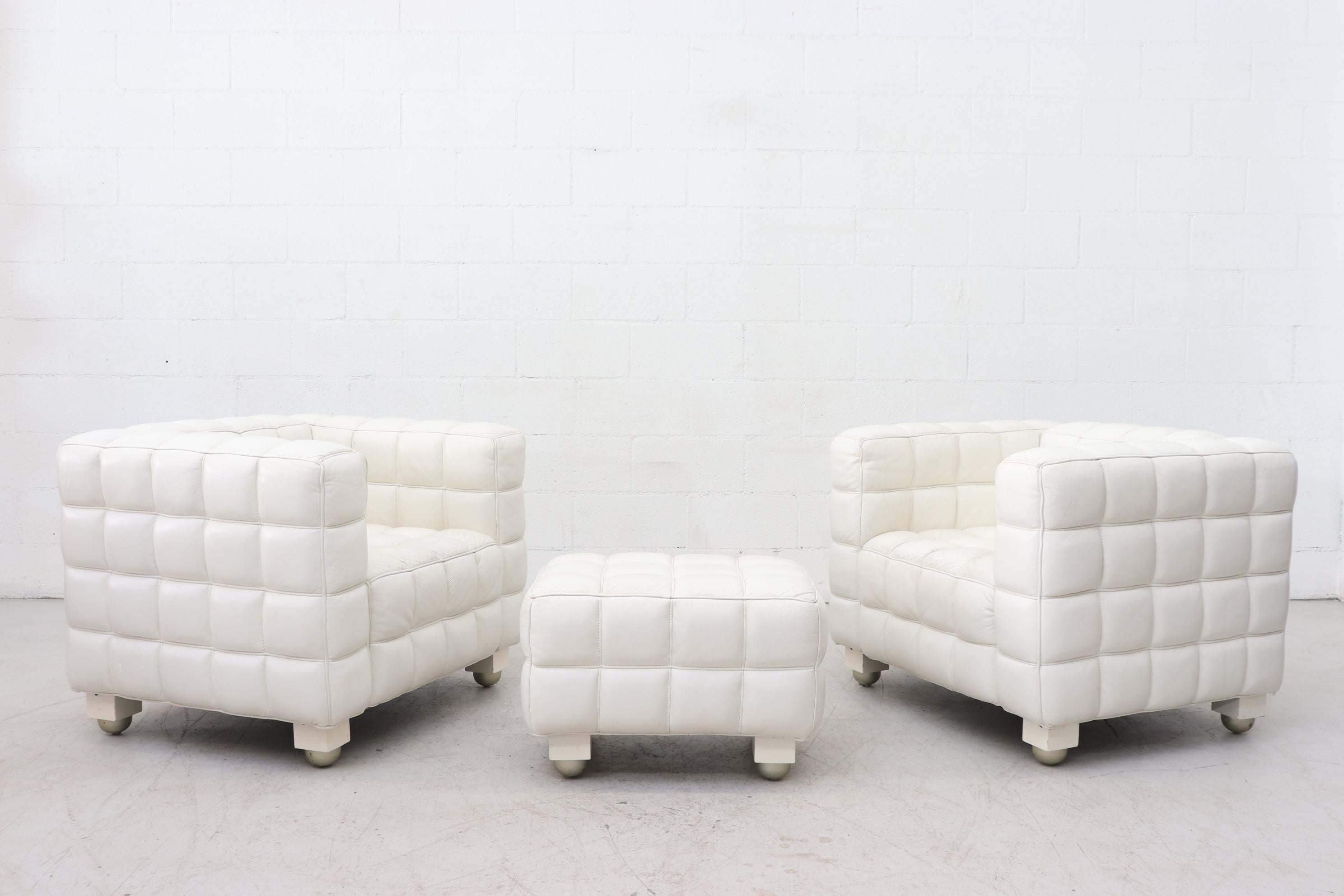 Pair of white leather Josef Hoffman Kubus style lounge chairs with ottoman. Mod quilted leather cube lounge chairs with strong lines on short wooden legs and silver ball feet. In original condition with visible wear, as pictured. Set price.