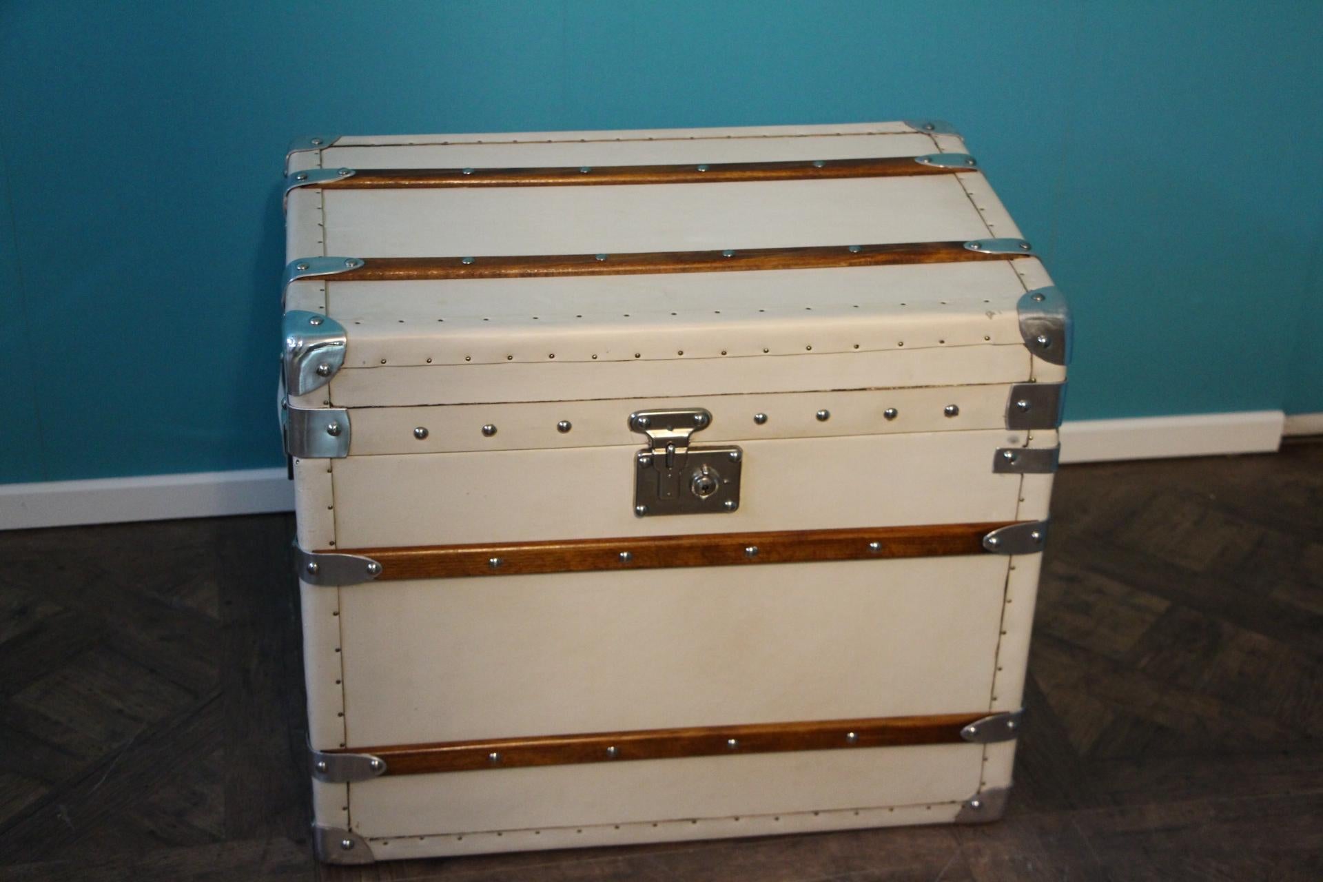 Very pretty steamer trunk made in wood and covered with white leather, wood slats, polished aluminum corners, polished steel lock and large leather side handles.
It is a very unusual color for a steamer trunk and thanks to its uncommon shape, it