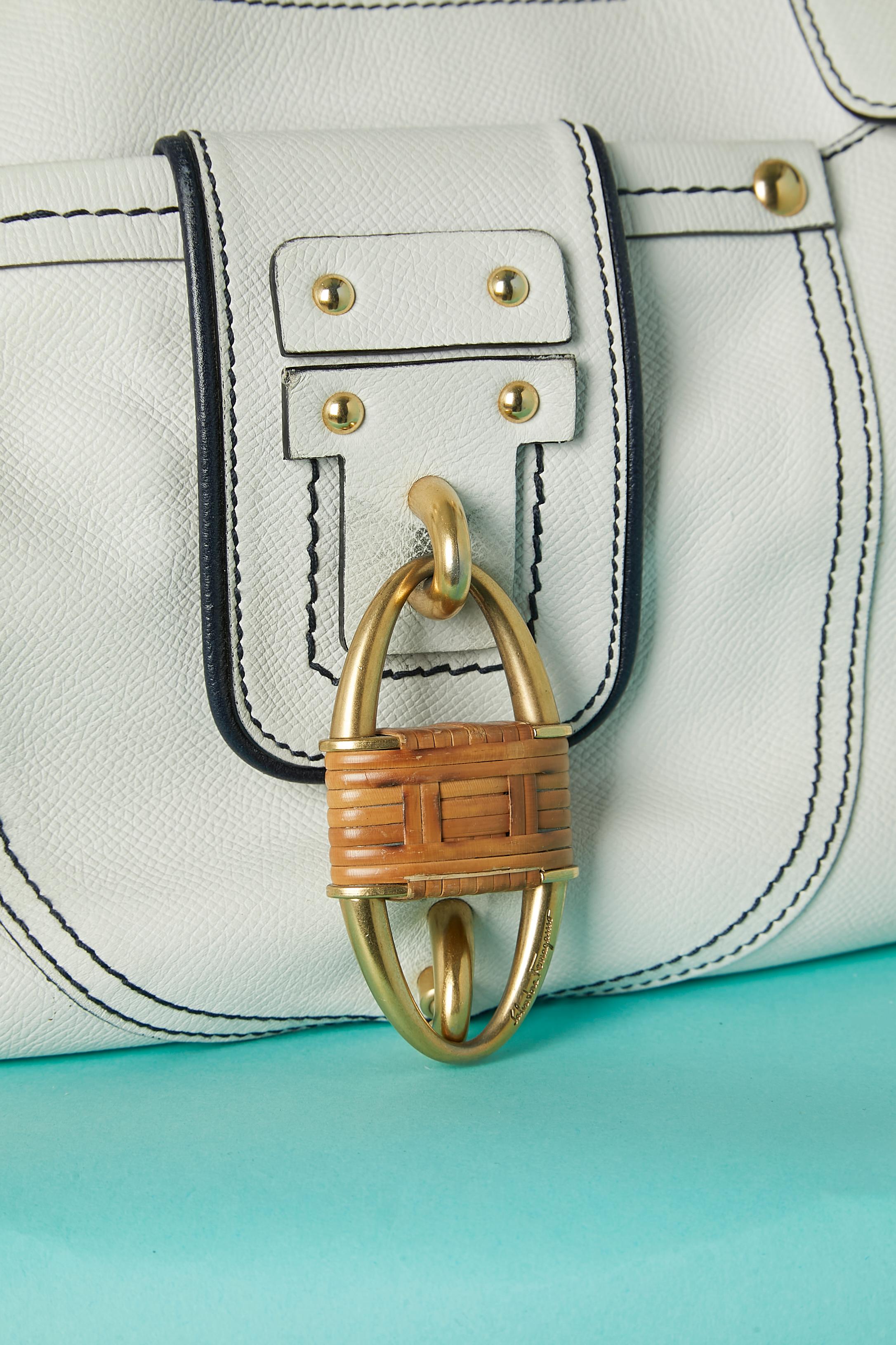 White leather top handle bag with branded nylon lining. One front pocket with silver metal locker covered with rattan. 
One large pocket inside with zip closure and 2 small flat pockets. Gold studs on the front and underneath the bag. 
Numbered: