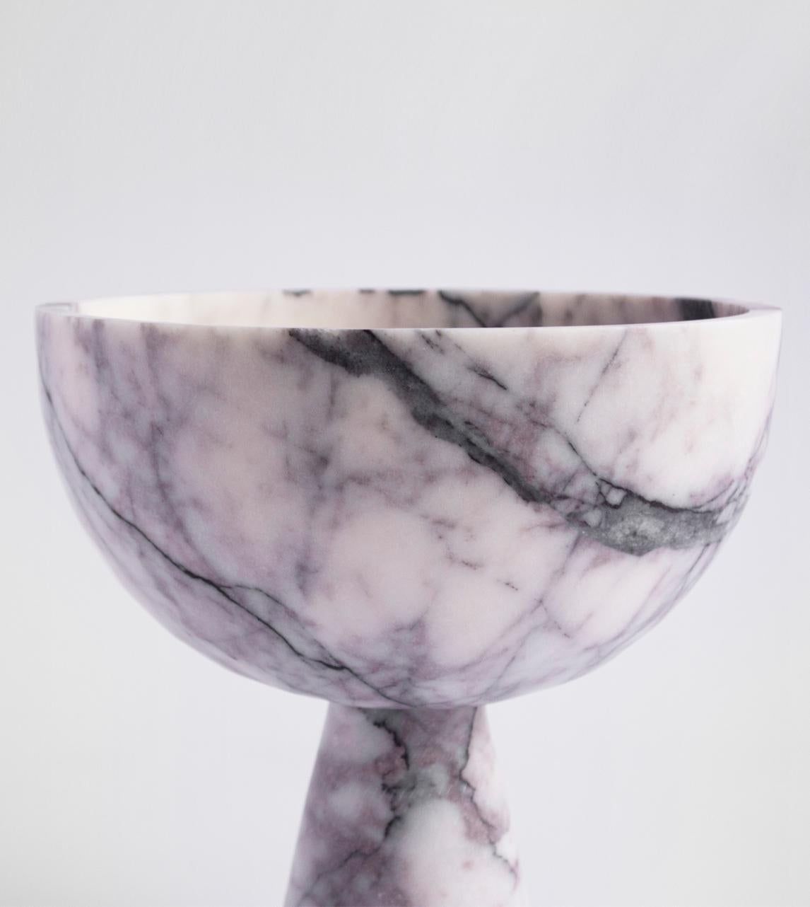 A substantial white marble bowl with unique lilac veining rests atop a pedestal for a grand presentation of fruits and vegetables. 

Exposure to the acid of citrus fruits can stain marble. Due to the natural properties of marble the colour and