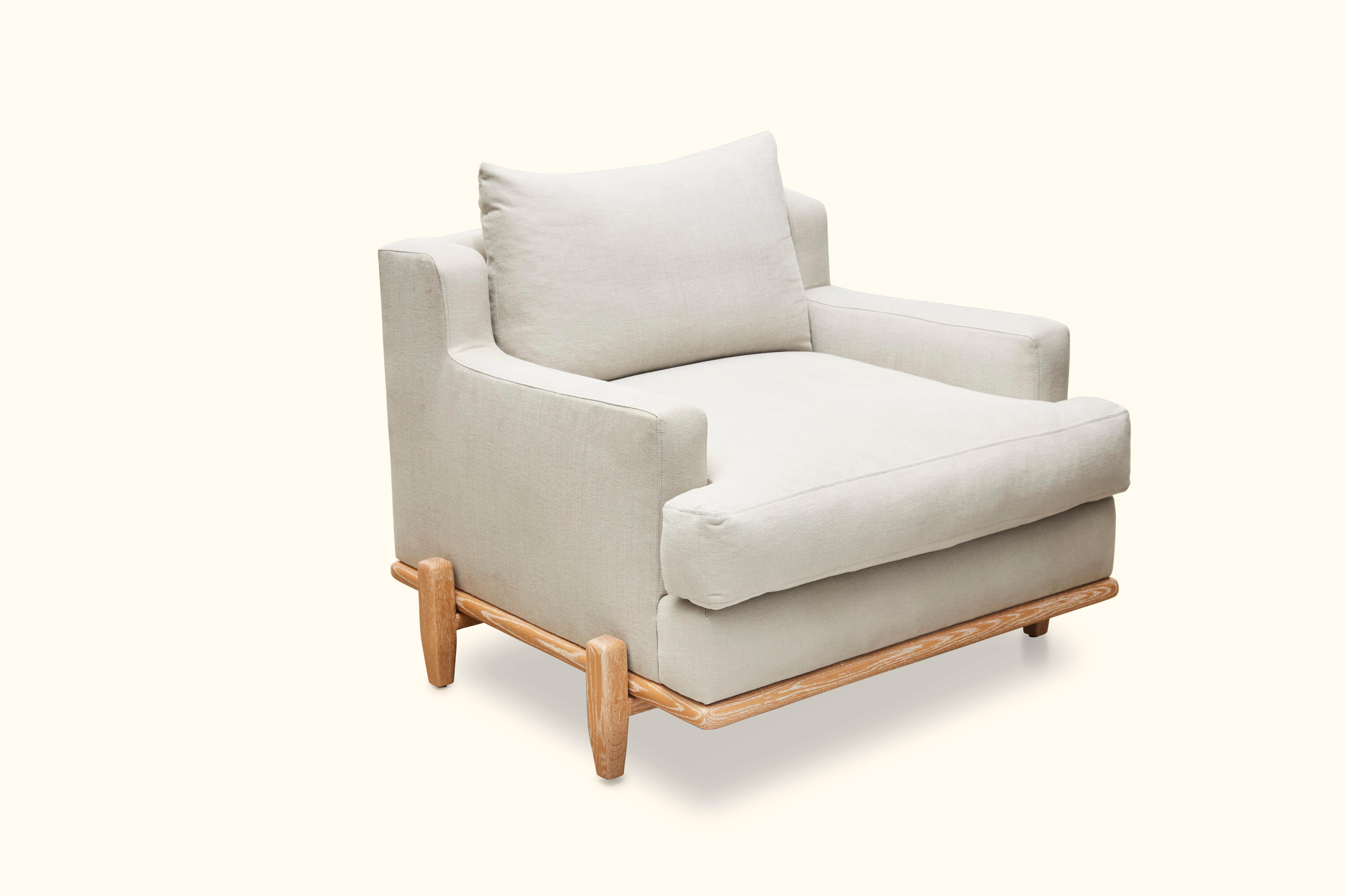 The George chair is part of the collaborative collection with interior designer Brian Paquette. The George chair is a low profile, but wide-scale lounge chair that rests on top of a solid wood base. Shown here in white linen and Cerused