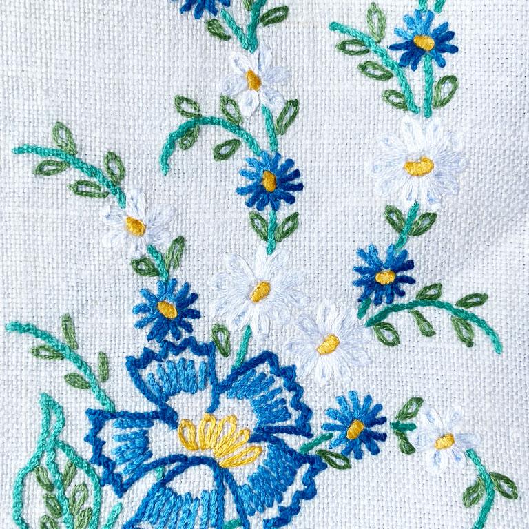 A pair of vintage linen floral tea towels or guest towels. Created from crisp white linen, this set features hand-embroidered flower details in blue, yellow, and green. Freshly pressed and ready for use. 

Dimensions:
18