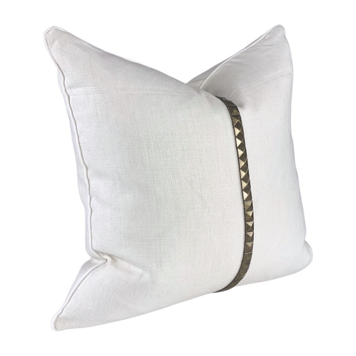 Translating luxury design, this high-end, white linen pillow injects contemporary aesthetics into interiors. The beautiful 100% heavy-weight European linen pillow features brassy metal stud detailing and is finished with elegant velvet trim piping.