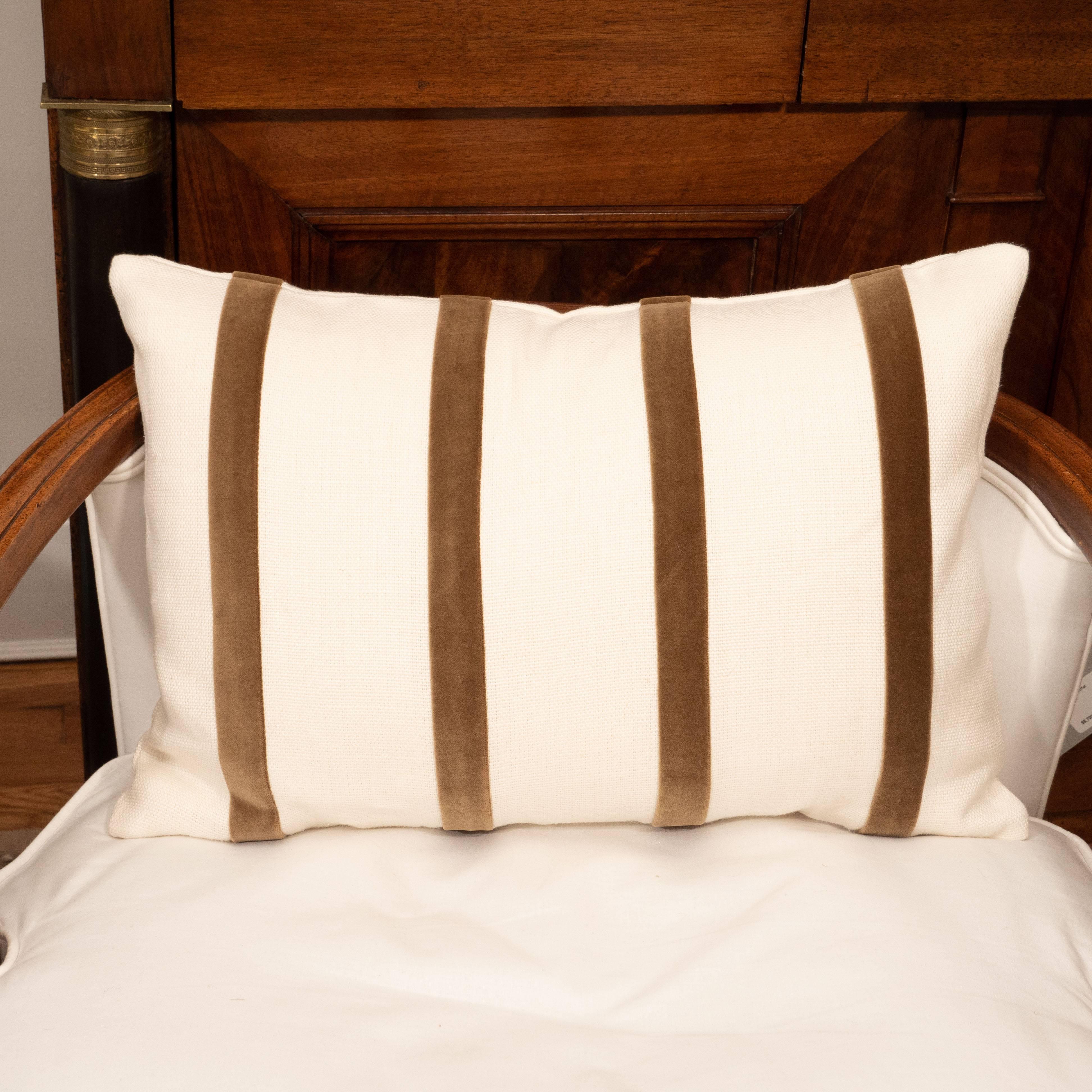 A white linen pillow with brown velvet stripe.