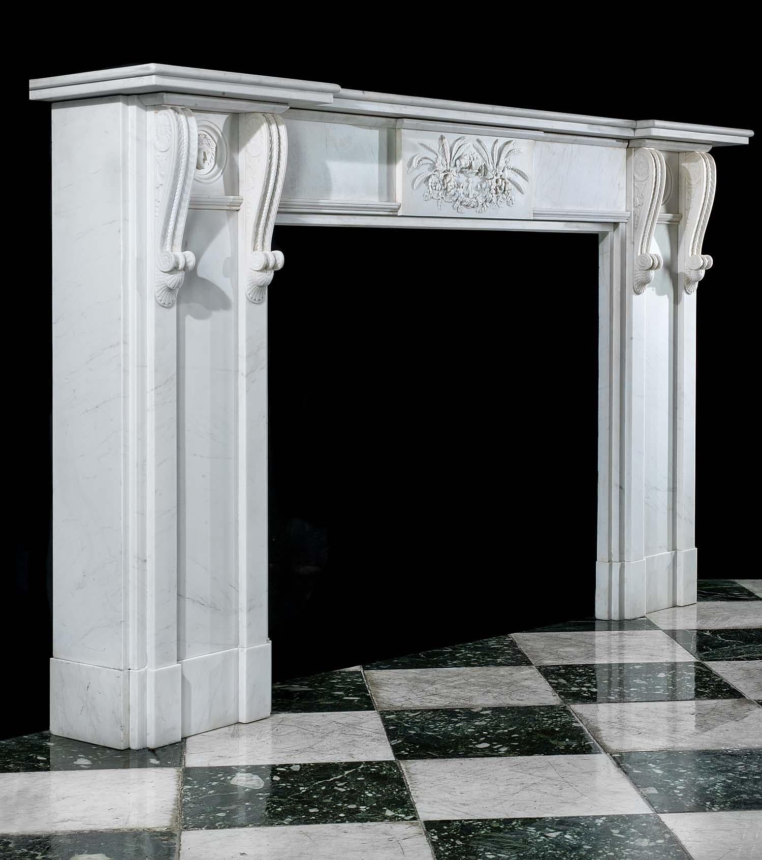 A large and very well executed white marble 20th century copy of a Regency chimneypiece. The wide breakfront shelf, which rests above a plain frieze centred by a large plaque decorated with husks, fruits and foliage, is flanked by two pairs of